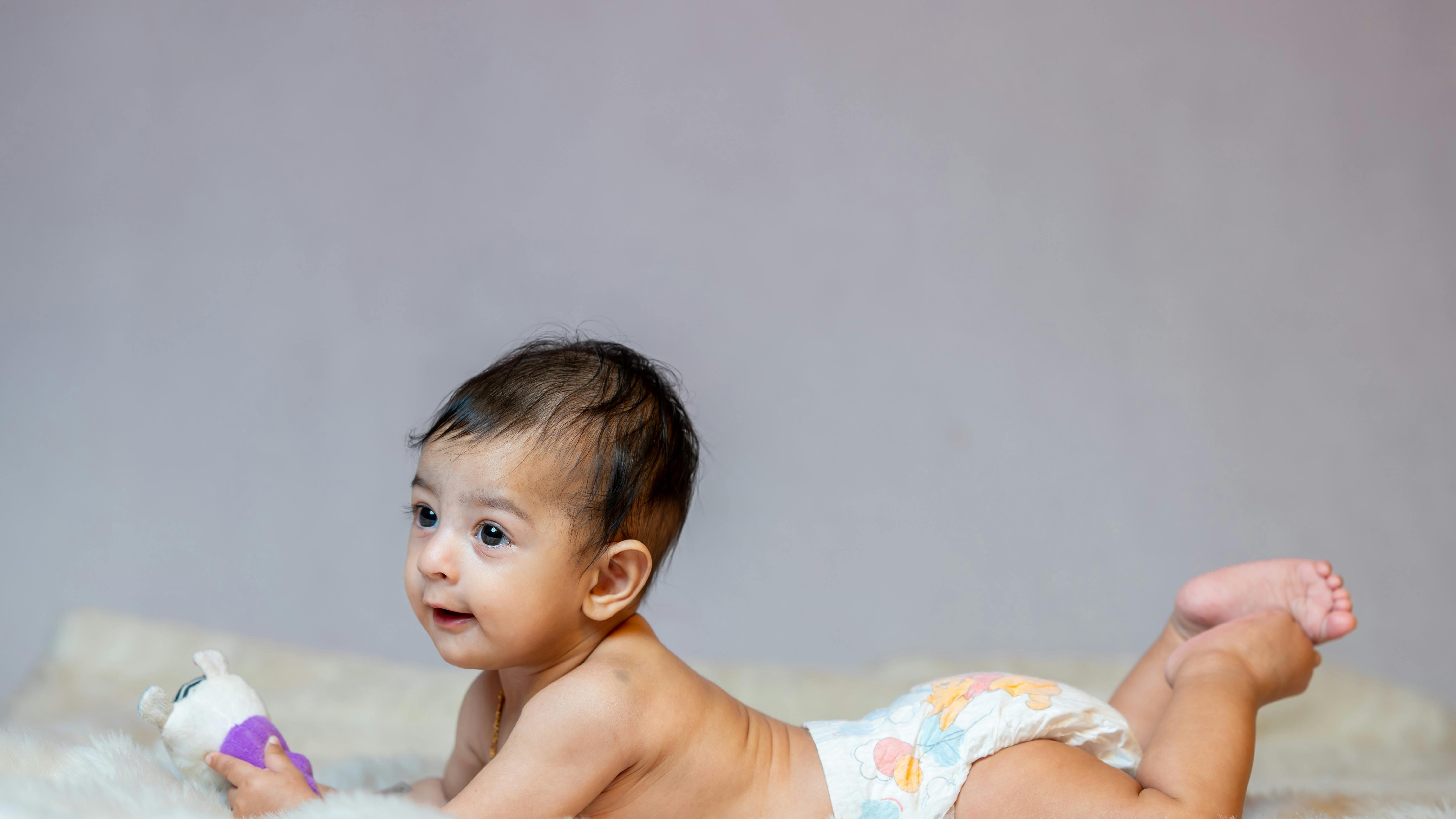 Baby in Elvie Rise Smart Bouncer & Bassinet, relaxed in floral onesie, serene nursery.