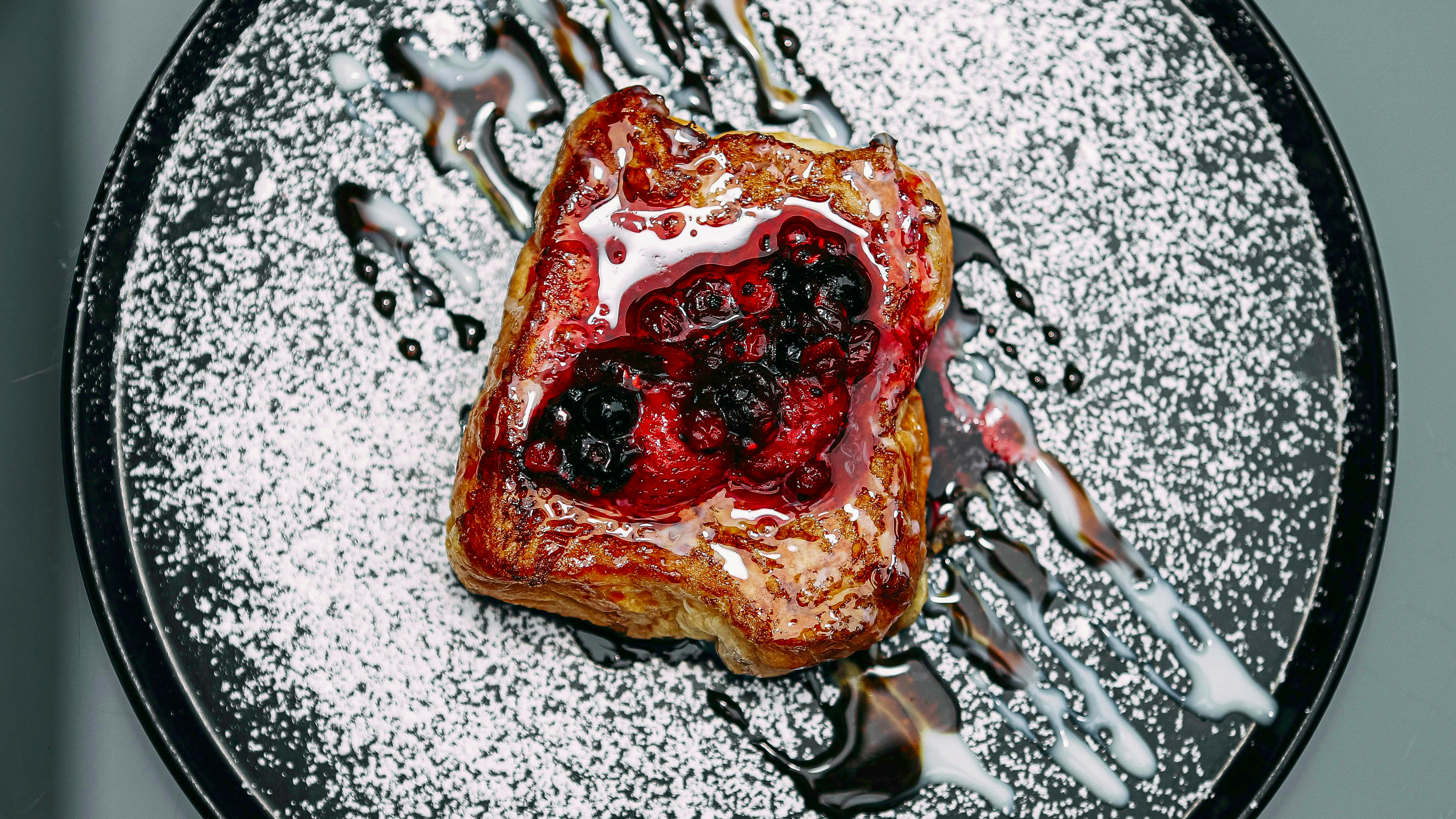 Easy French Toast sticks with fruits and syrup on a pink plate.