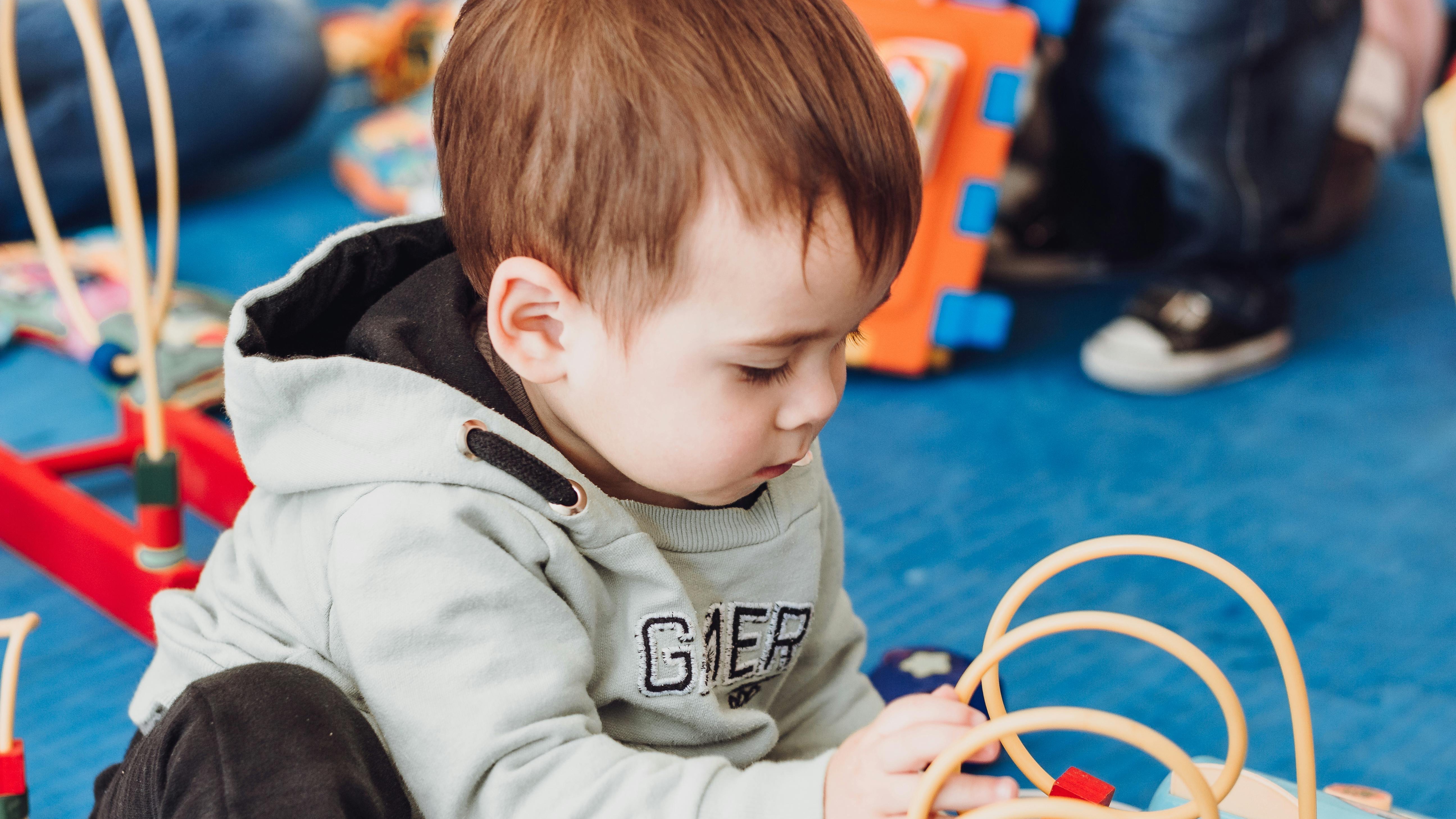 Child playfully hanging upside down showing energetic behavior.