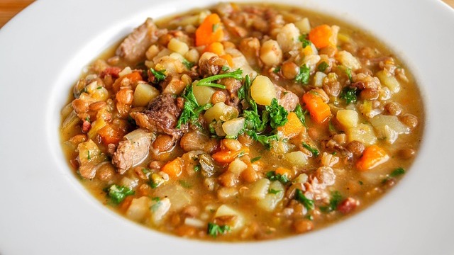 One-Pot creamy chicken stew in bowls with biscuits on a marble surface.
