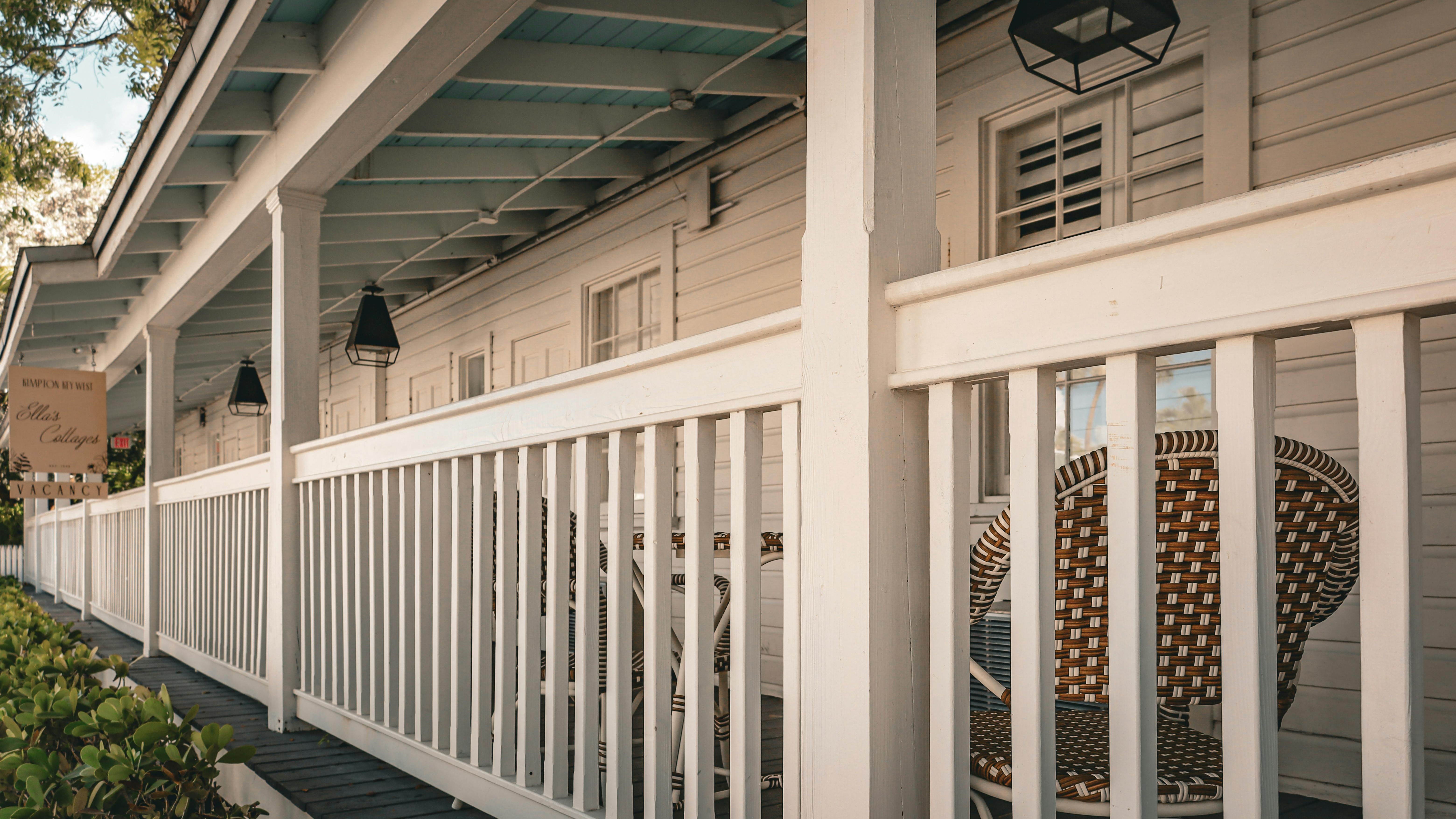 Cozy porch with space-saving DIY furniture, couple enjoying drinks.