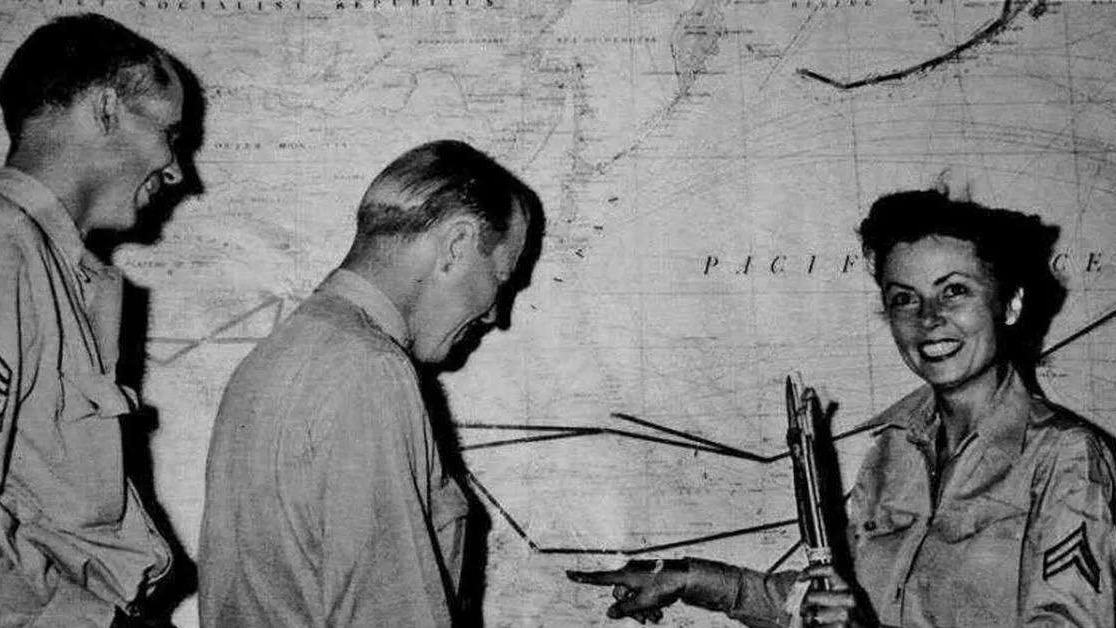 Military officers discussing WWII rescue operation over a map.