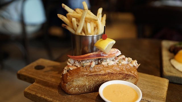 Well-groomed man sitting in a striped shirt, calm expression.