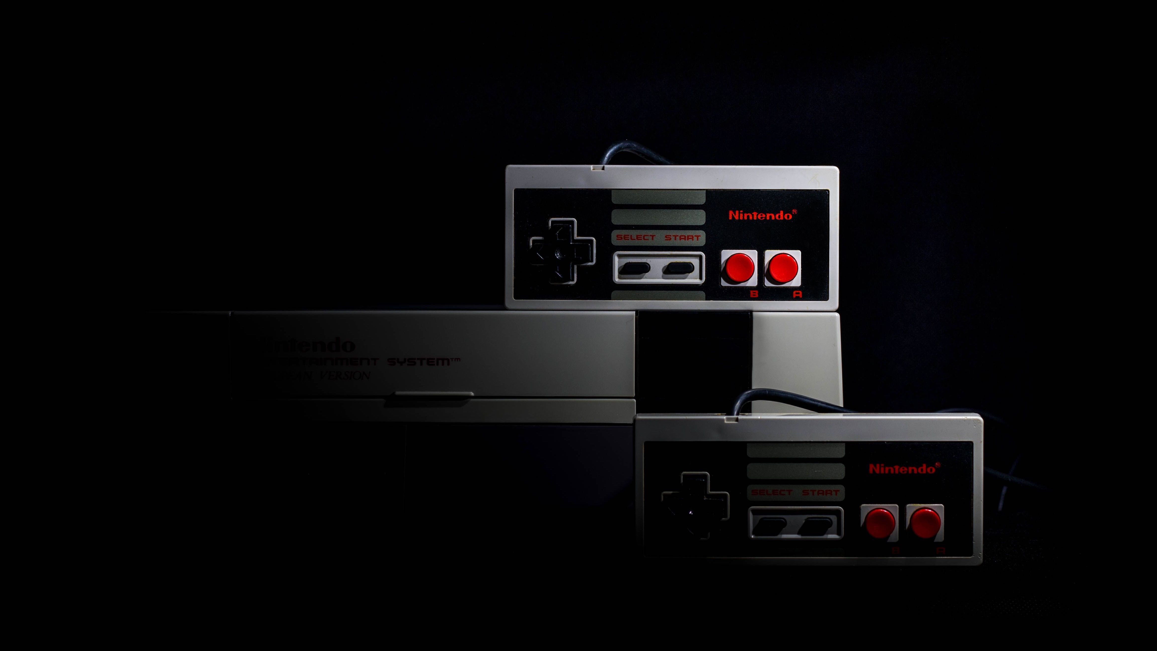 Man discussing NES and SNES classics in front of vintage consoles.