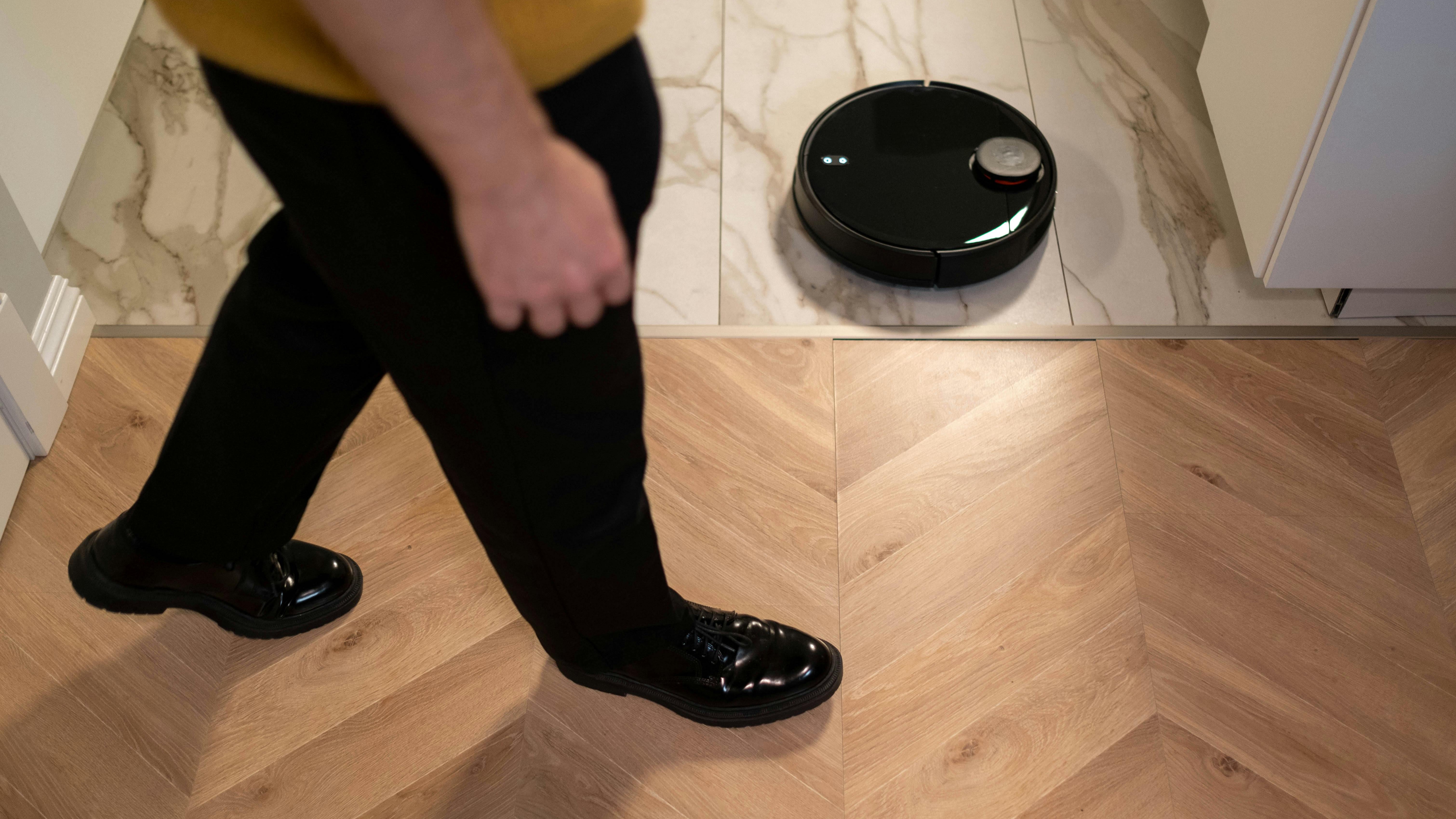 Self-emptying robot vacuum with smartphone app and big savings text.