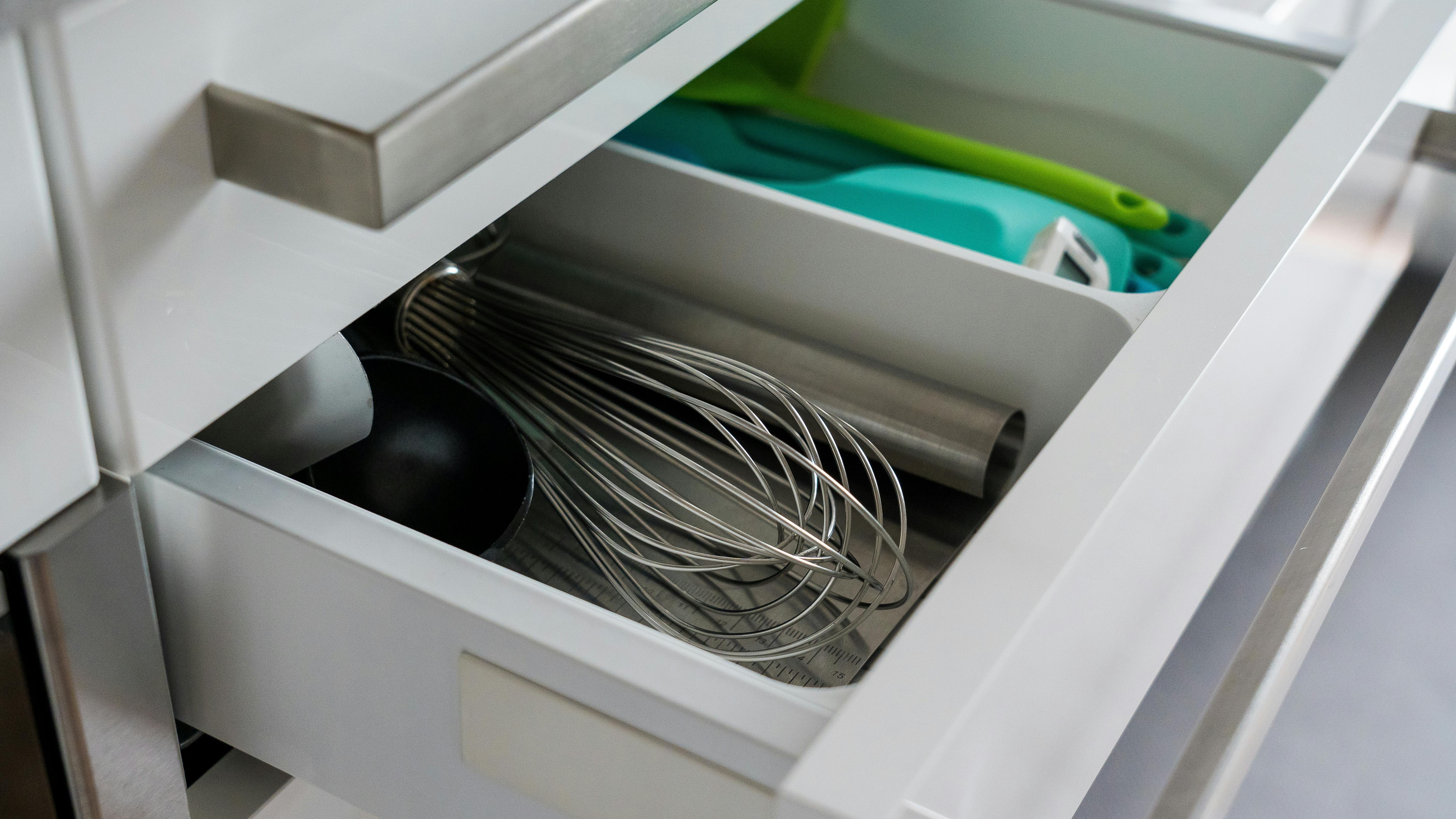 Neatly organized cabinet drawer with plastic containers.