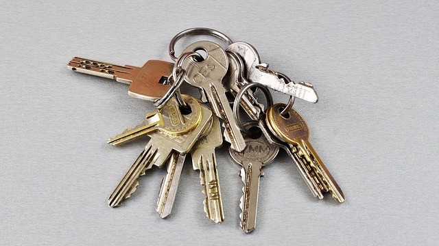 Assorted old keys with keychains on a patterned cloth.