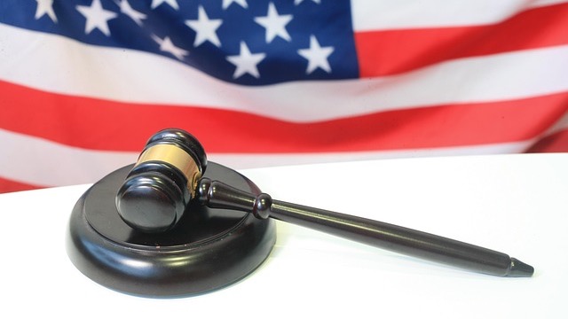 Blurred figure in shadow, suggesting retaliation for reporting misconduct.