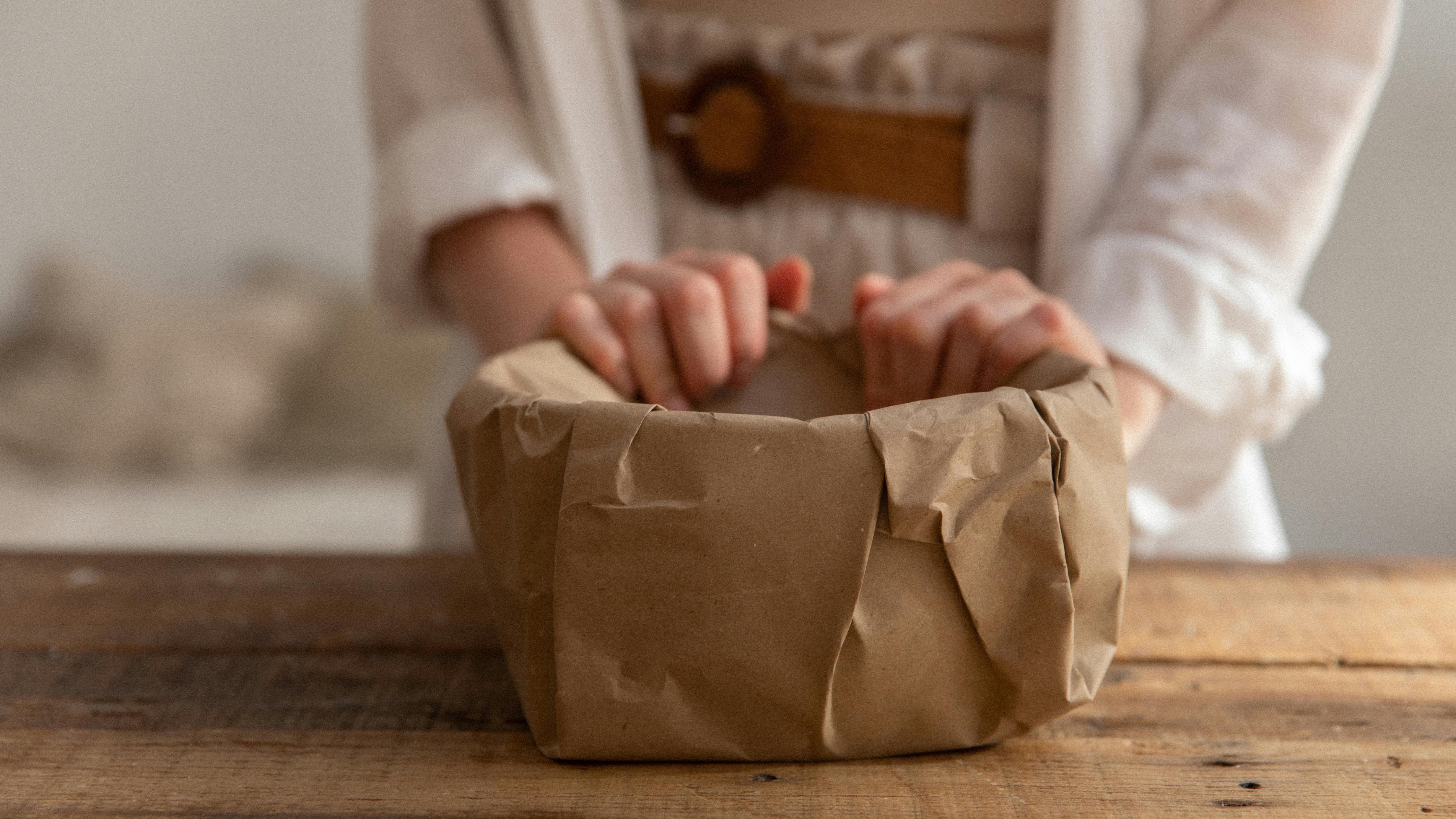 Young boy playing with easy paper tunnels for toy cars in a bright hallway.