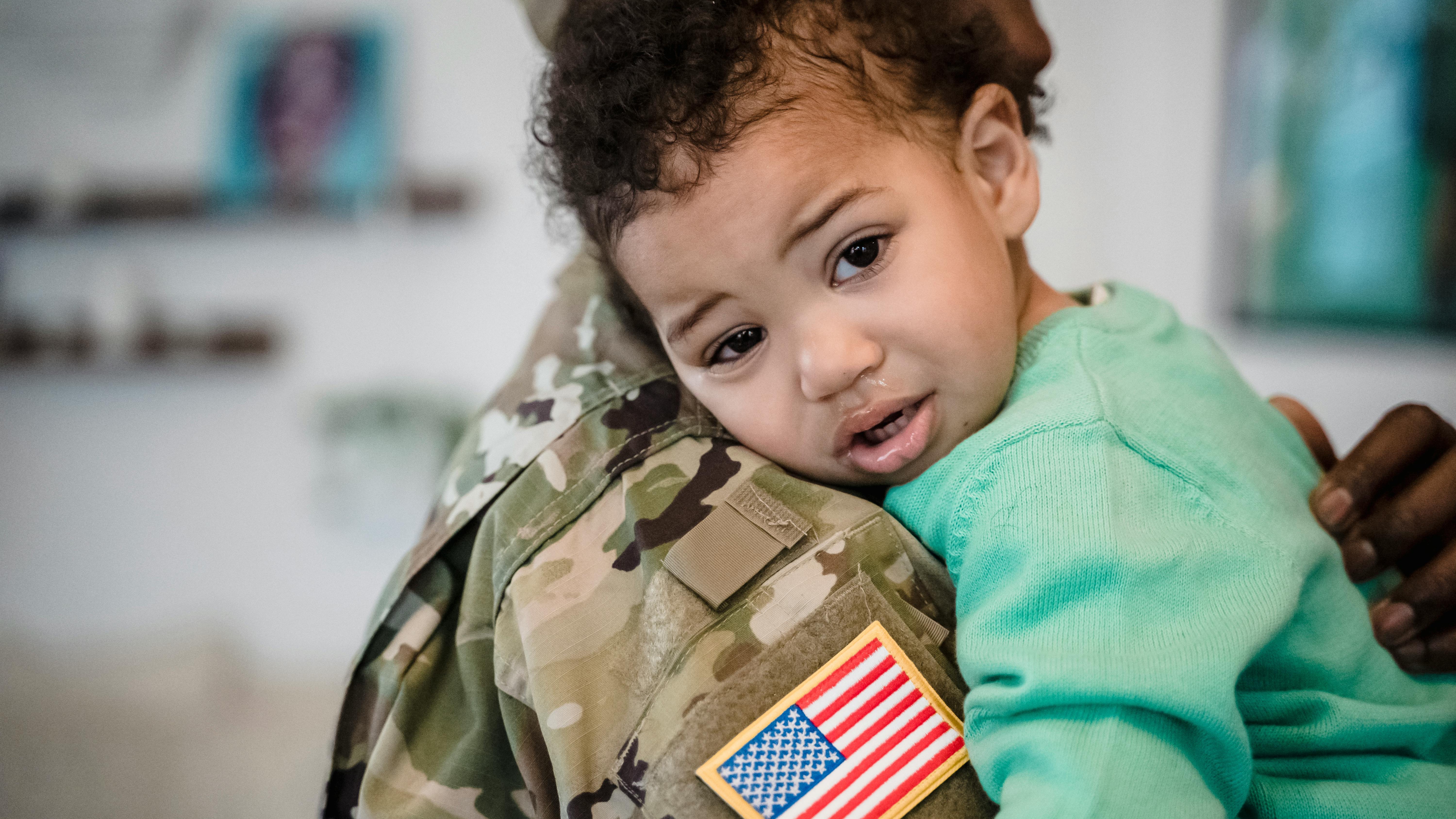 Military reunion depicting a child hugging a soldier.
