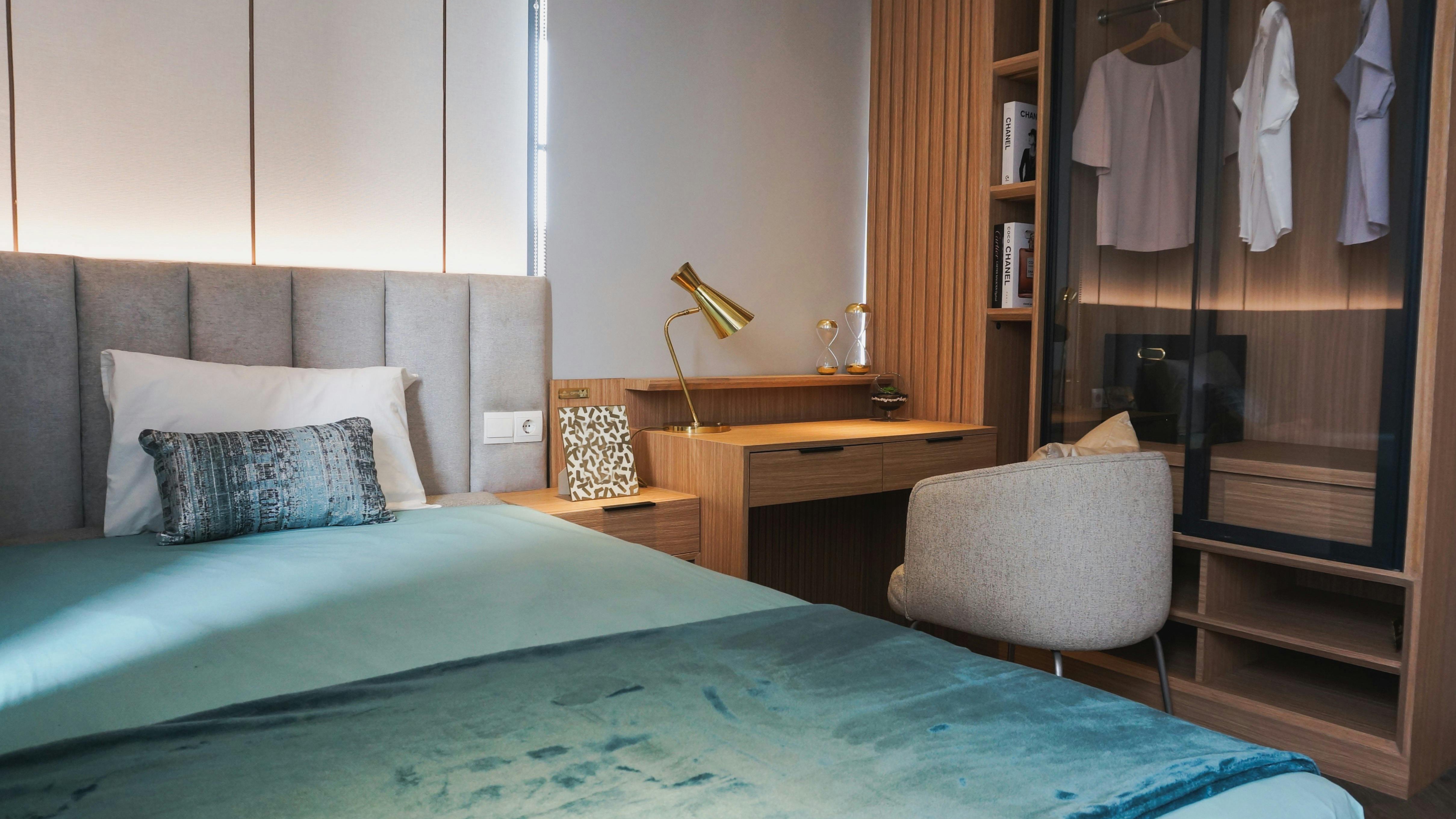 Bedroom with dark teal walls and cozy fireplace, 2026 paint trends.