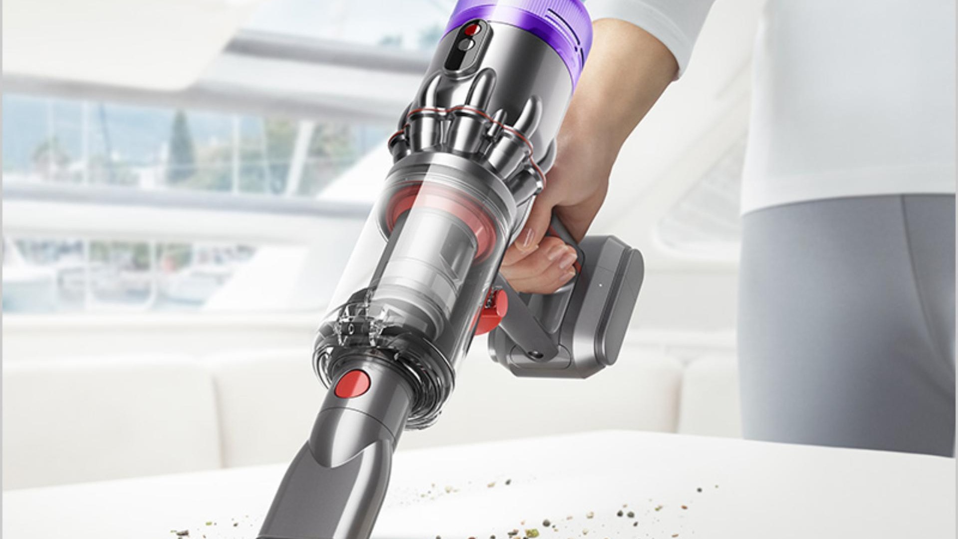 Dyson vacuum cleaner in use in a cozy living room setup.