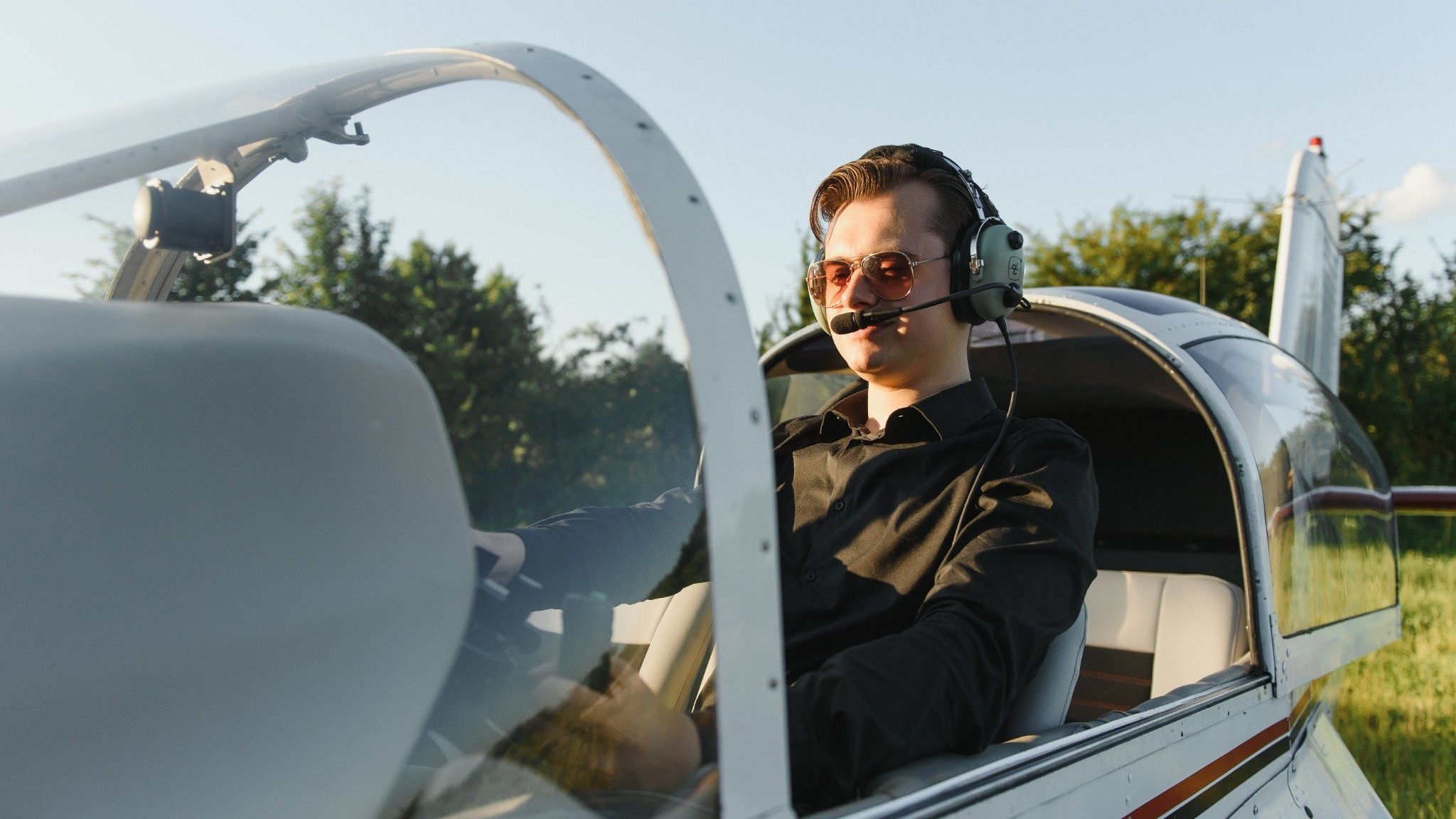 Valor in Action: Aviator in silver flight suit beside black aircraft.