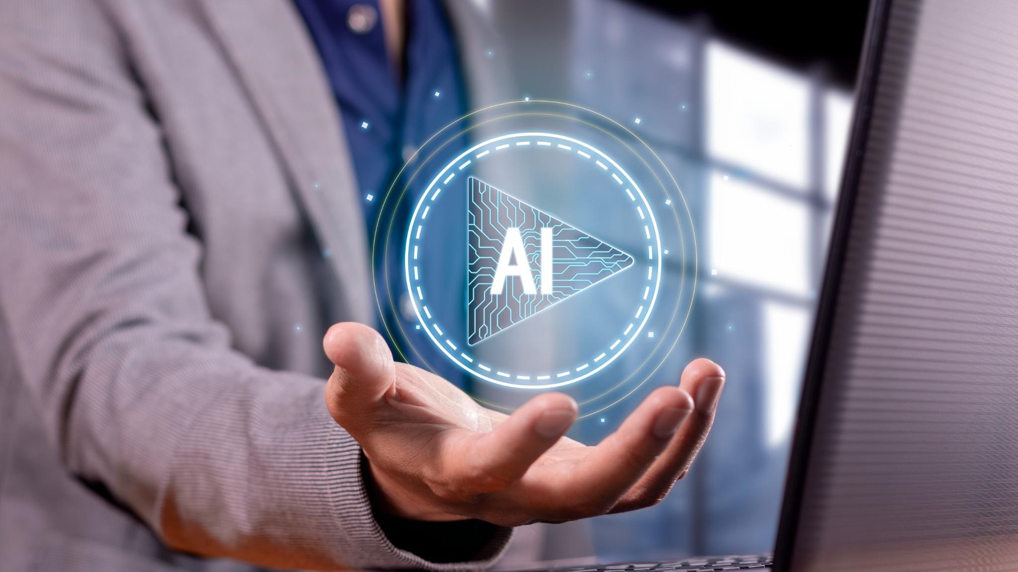 Bald man in suit speaking with focus, light blue backdrop, AI software shakeout.