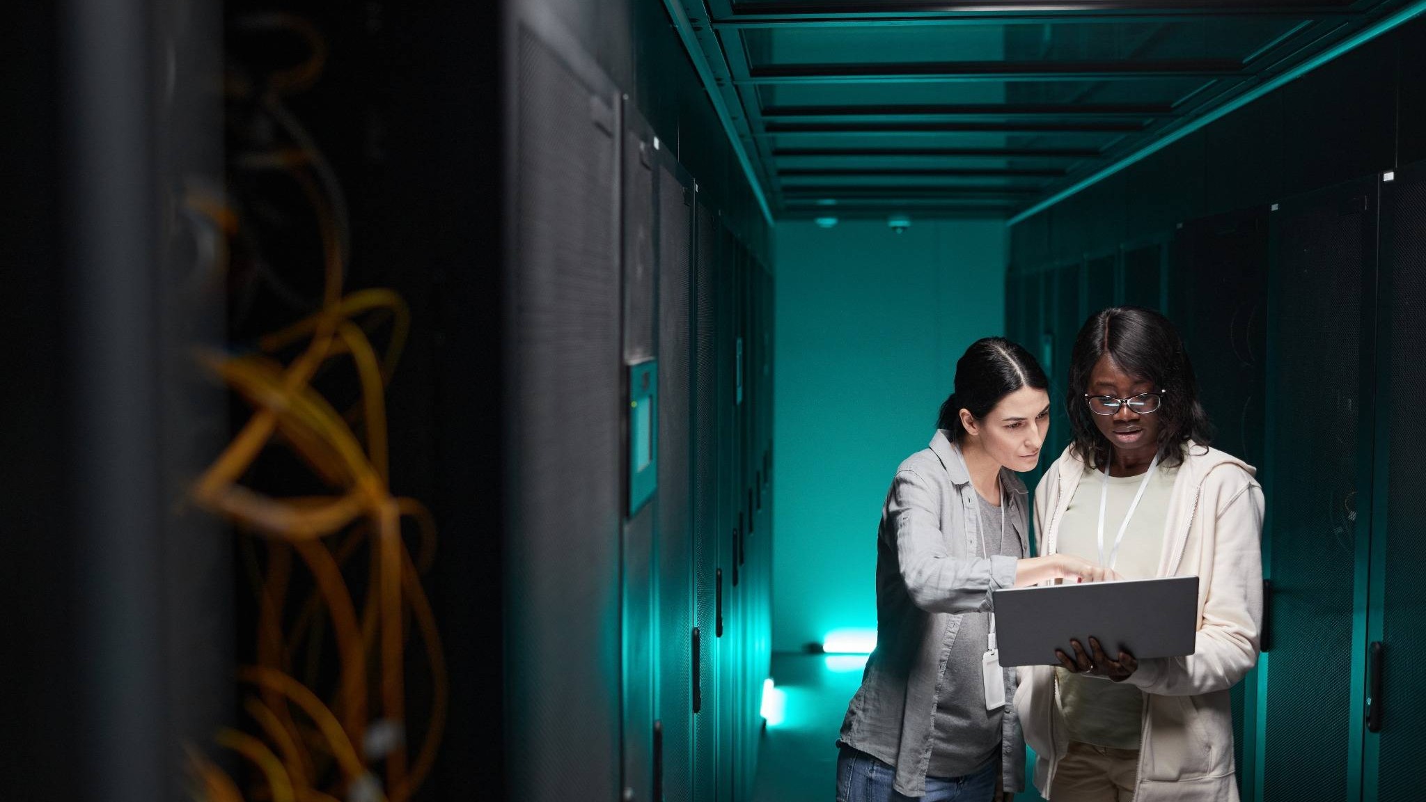 Modern data center corridor illustrating real AI bottleneck with server racks and cables.