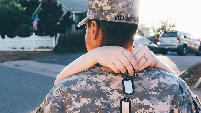 Heartwarming reunion of little girl and soldier with an American flag.