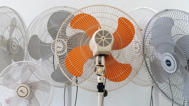 Close-up of air circulator fan grille with brand logo, pink background.