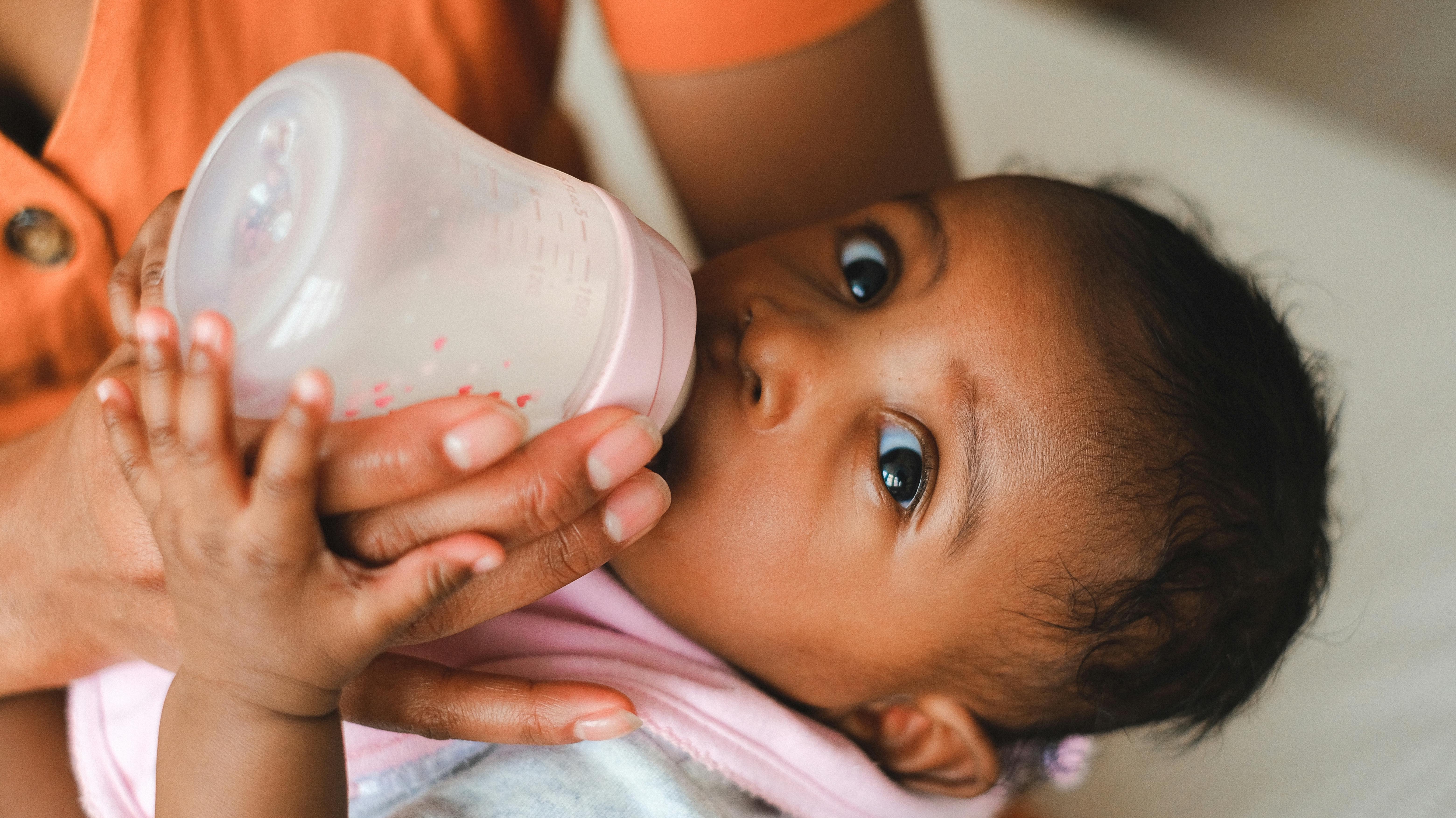 Infant formula cans and bottles on kitchen counter, whole milk vs skim milk discussion
