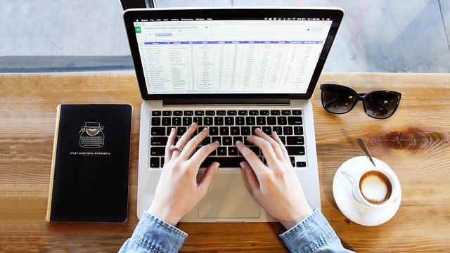 Young woman in office combating burnout, holding coffee.