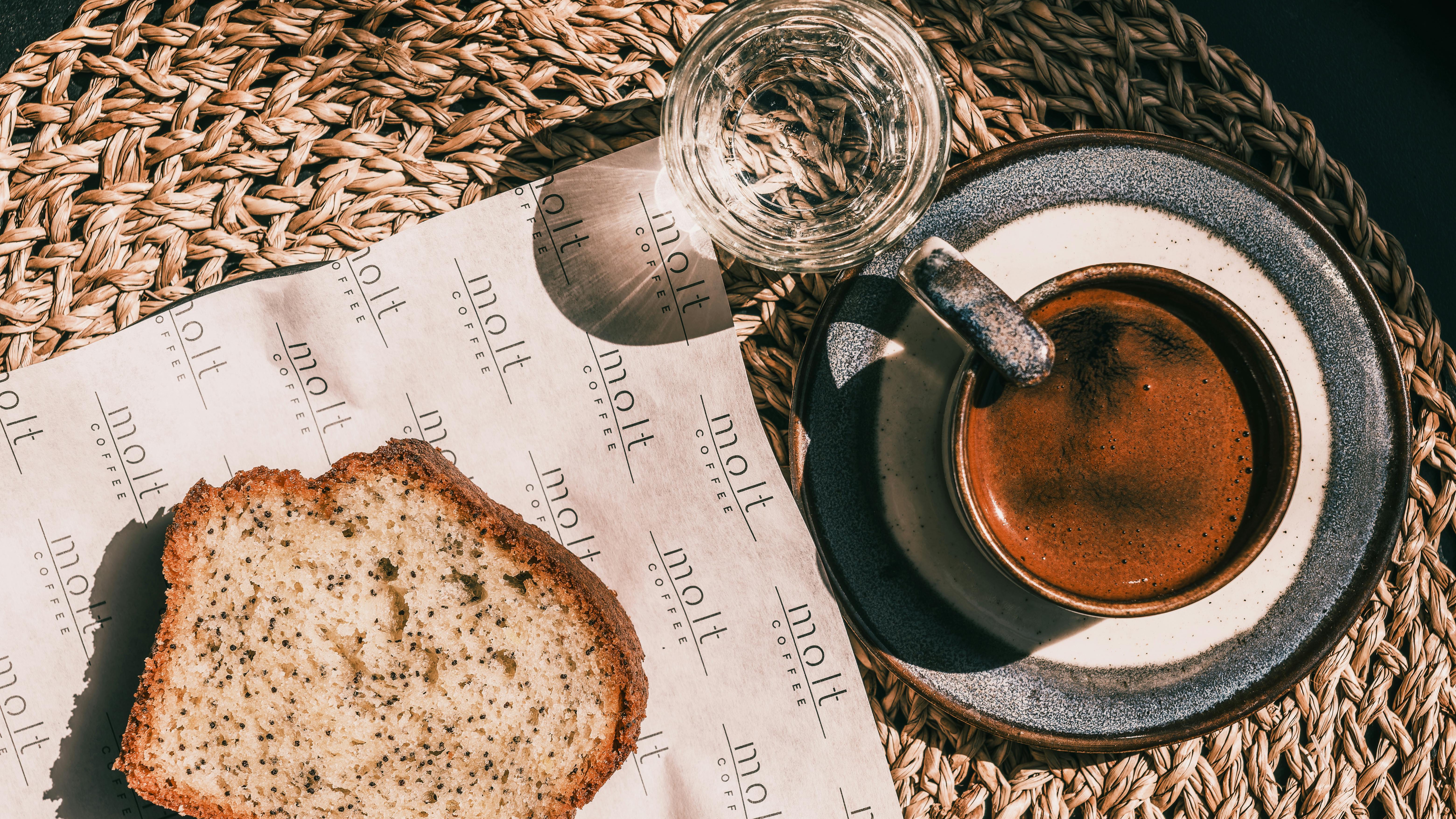 Berry breakfast cake with raspberries on textured pink surface.