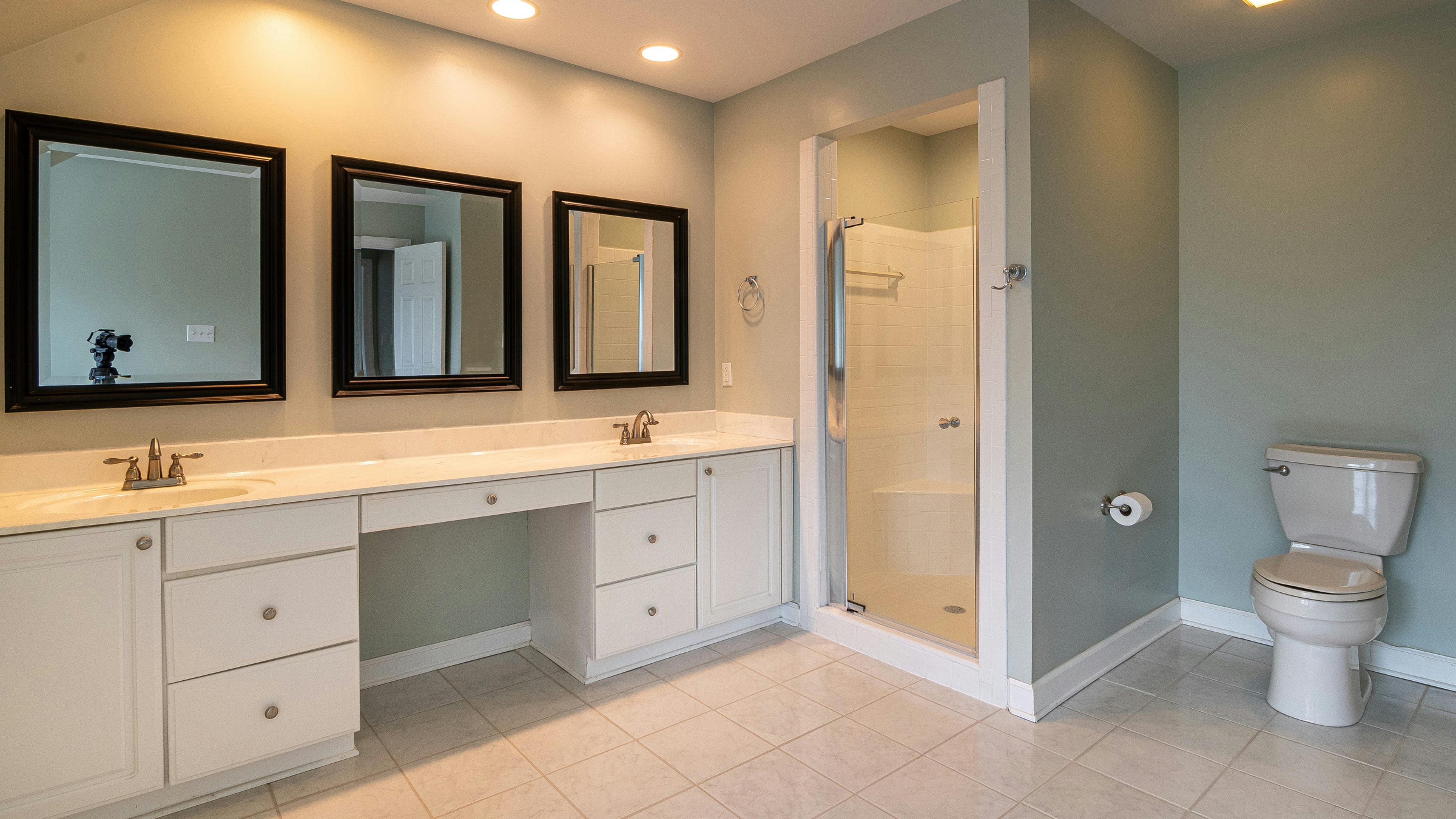 Minimalist bathroom with window, clawfoot tub, and rustic chair.