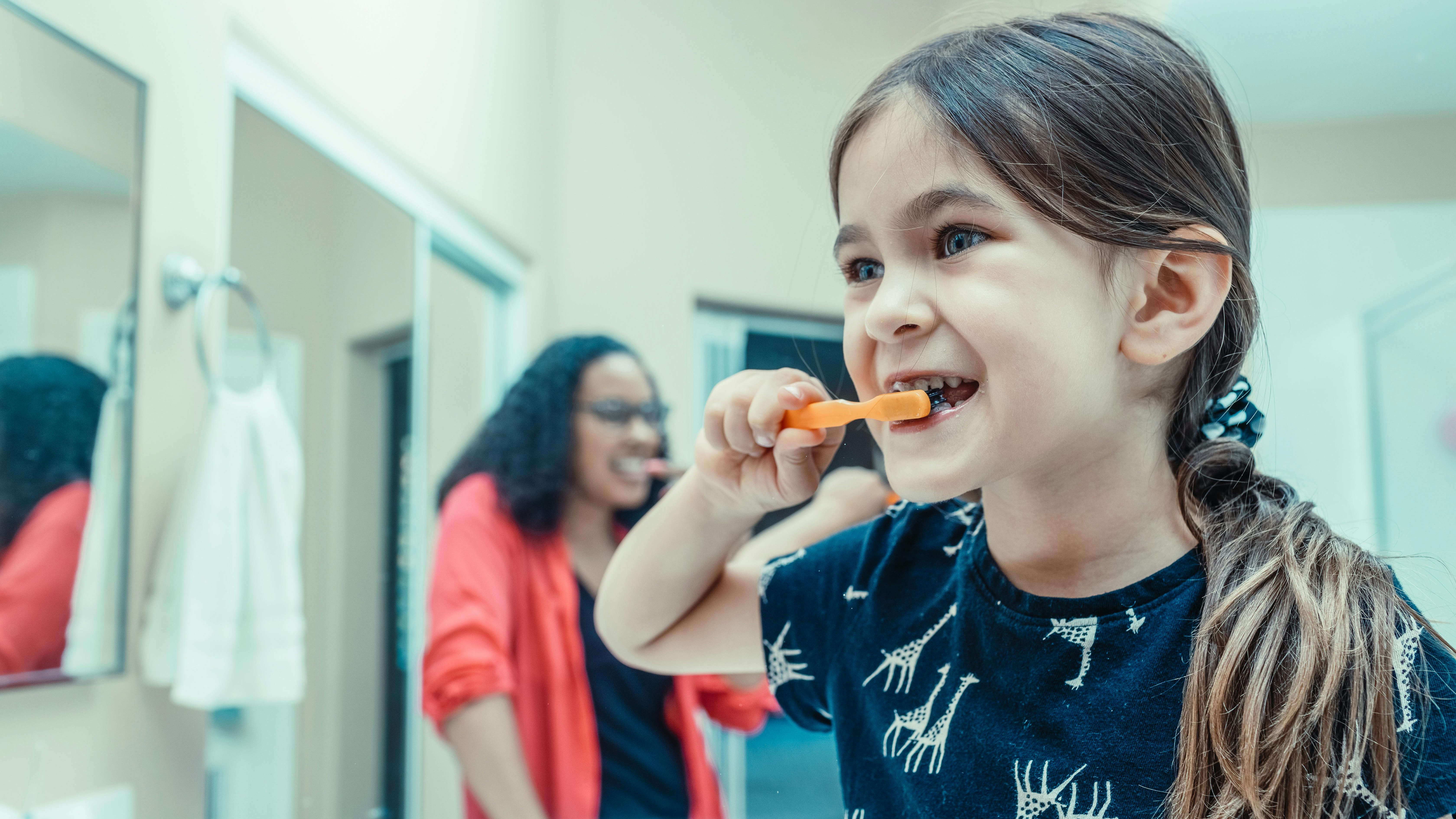 Joyful toddler brushing teeth, demonstrating good behavior.