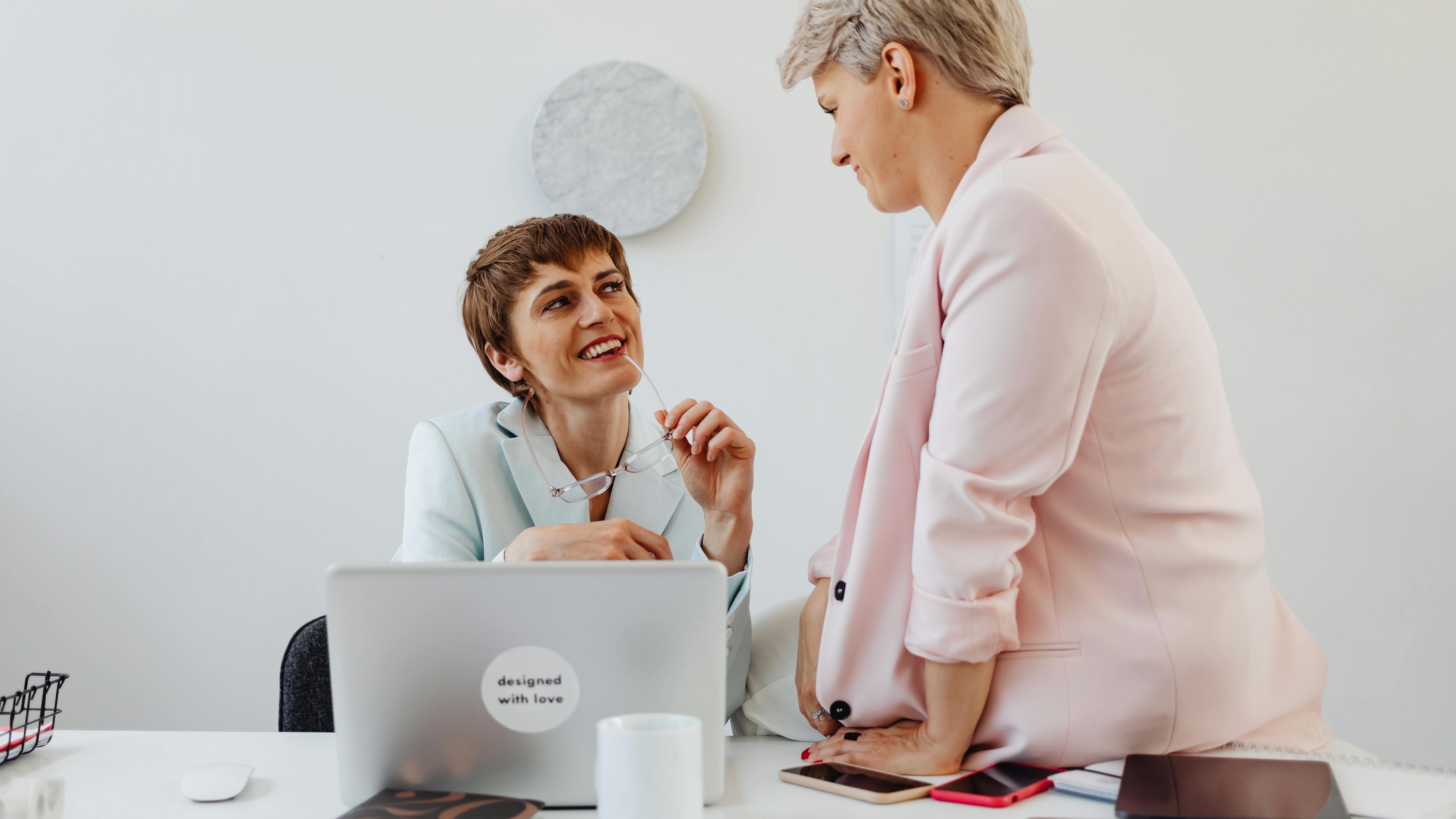 Two professionals discussing leadership at SHRM conference, active listening for inclusive leadership.