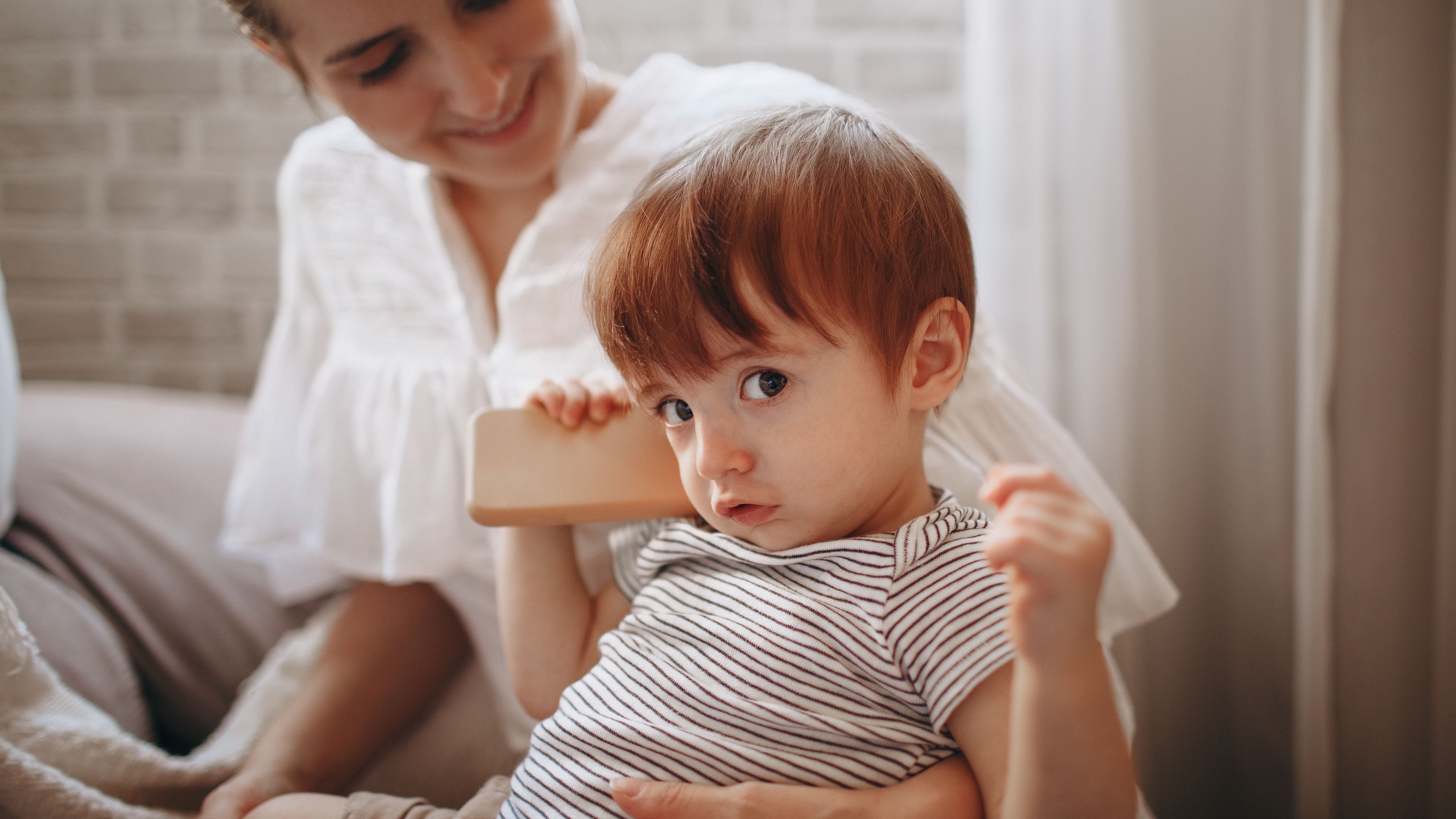 BCG Canada caregiver support scene with a young woman holding a baby in the kitchen.