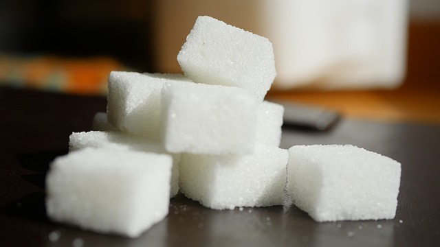 Child surrounded by sweets illustrating sugar intake concerns.