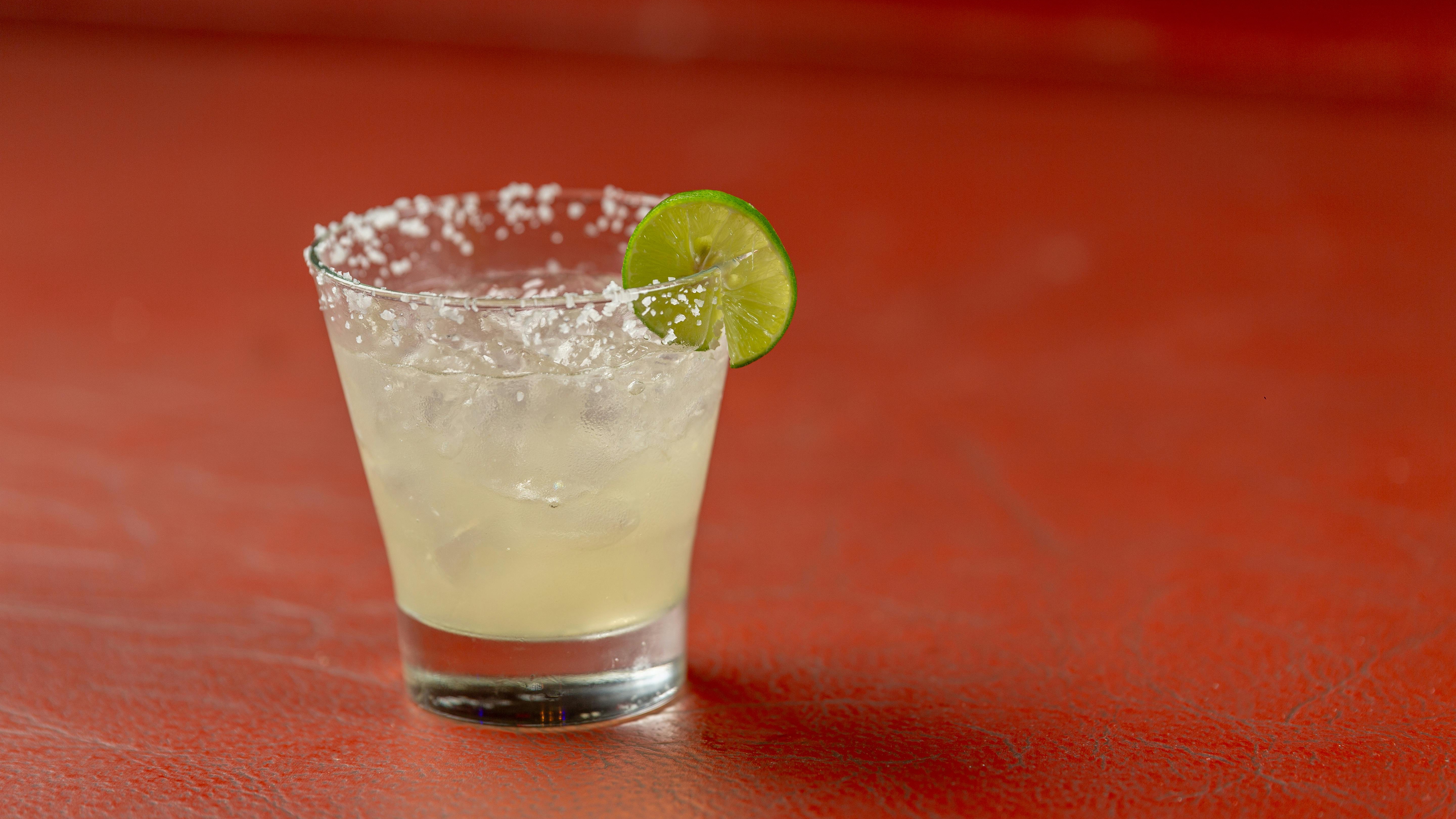 Friendly bartender at San Antonio restaurant with green cocktail.