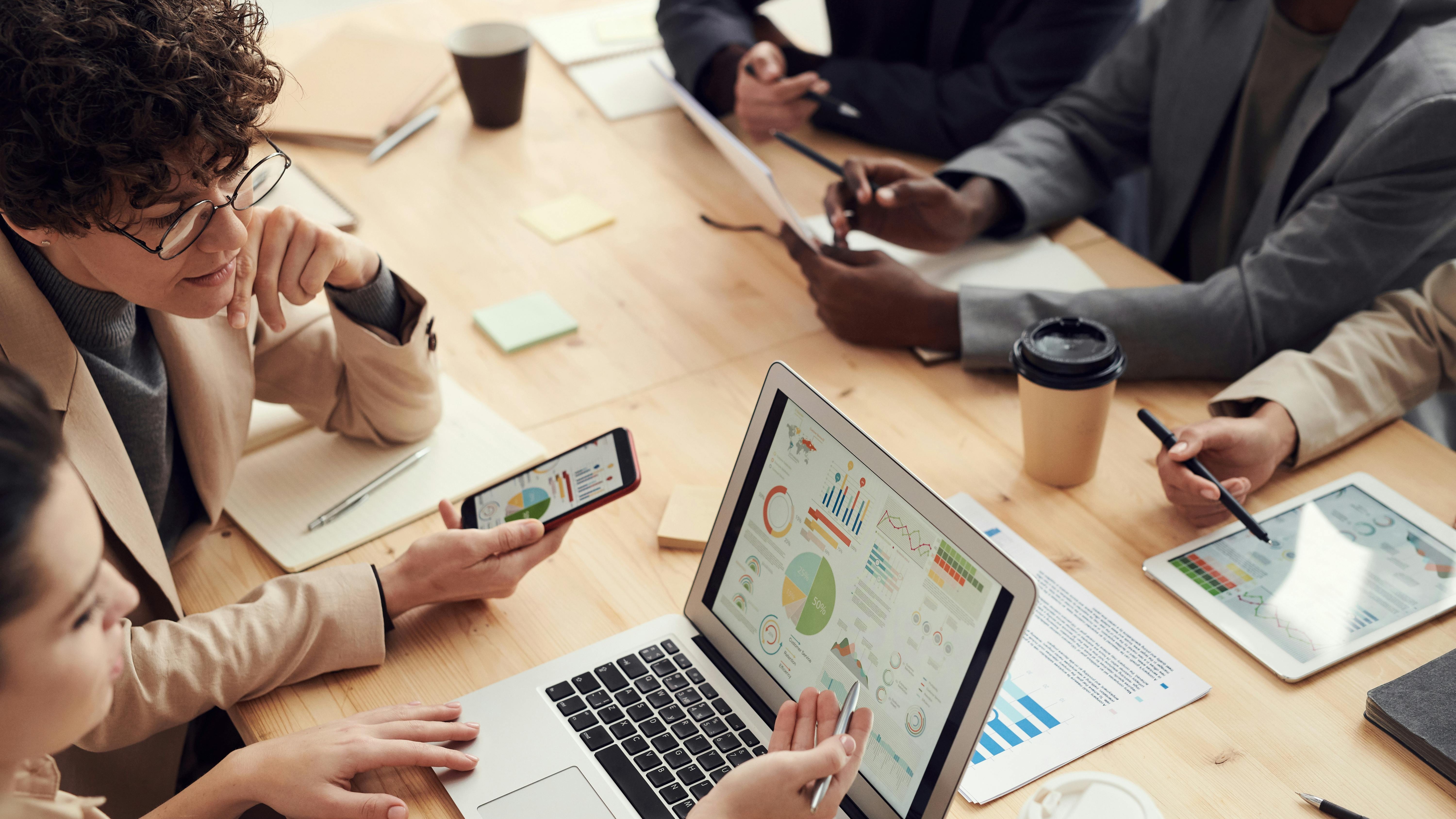 Focused woman using laptop in modern office, illustrating AI agents in the workplace.