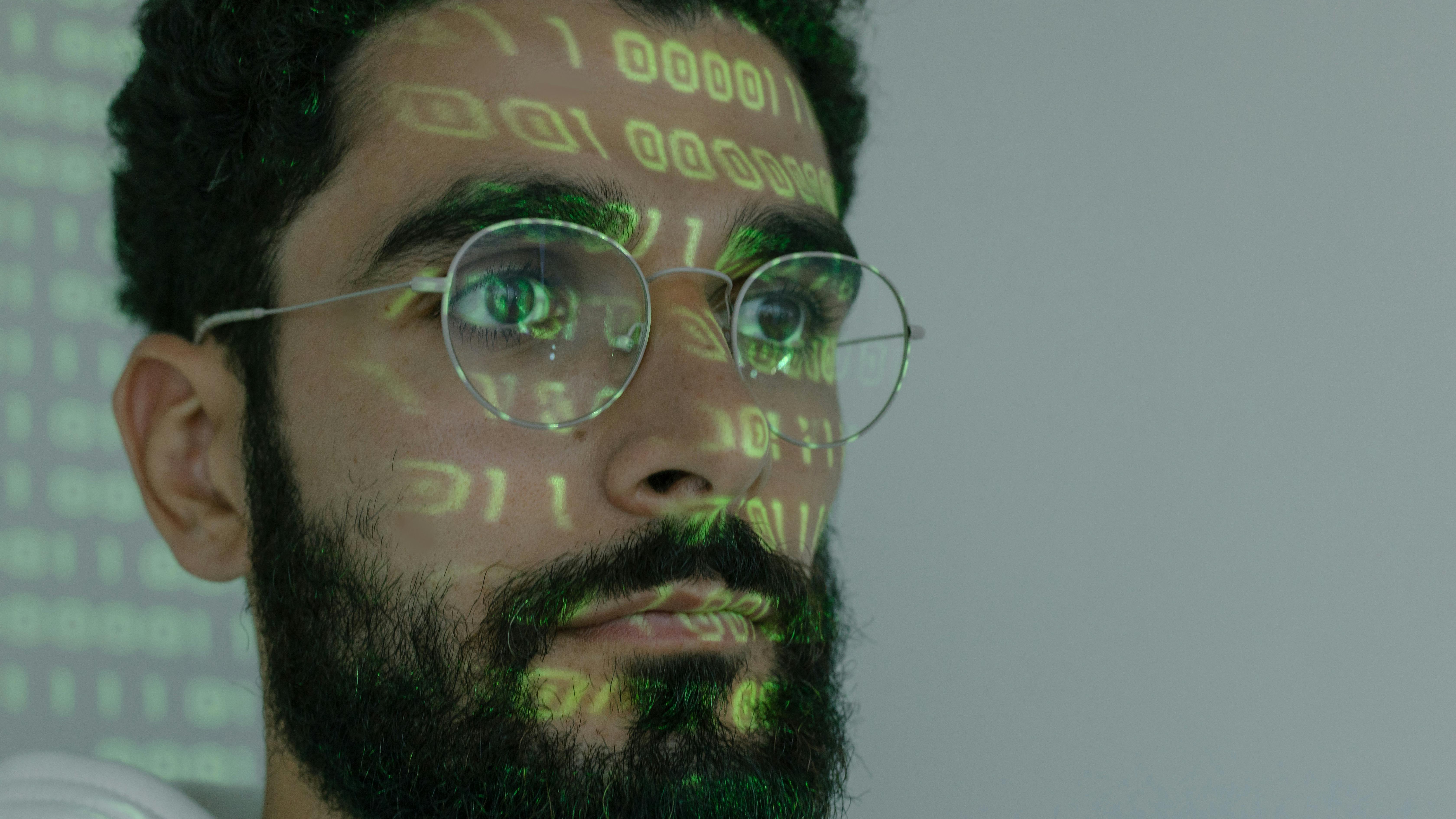 Software developer focused on screen, dimly lit room.