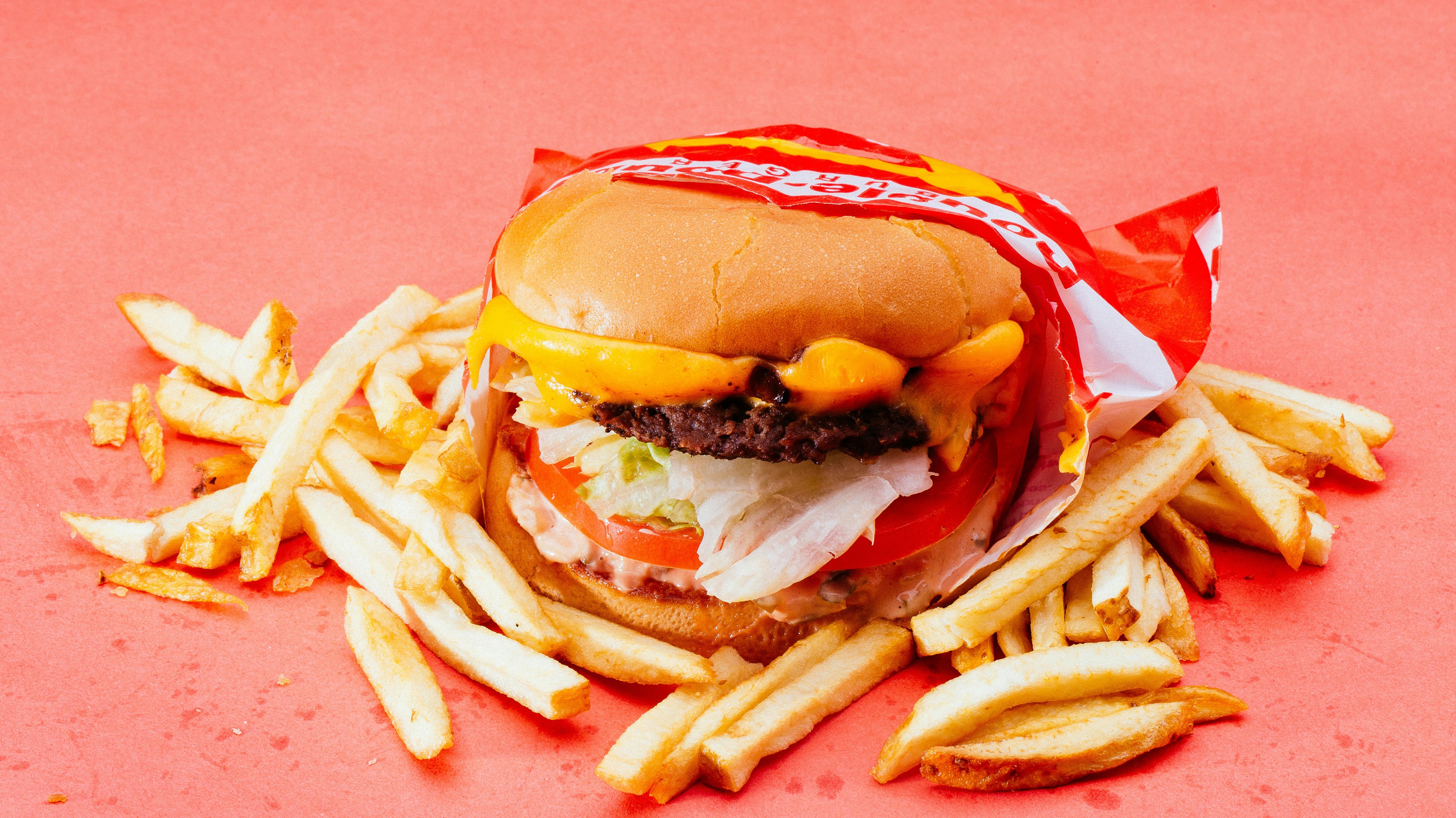 Closed Biff Buzby's Burgers storefront with blue awnings and cars.