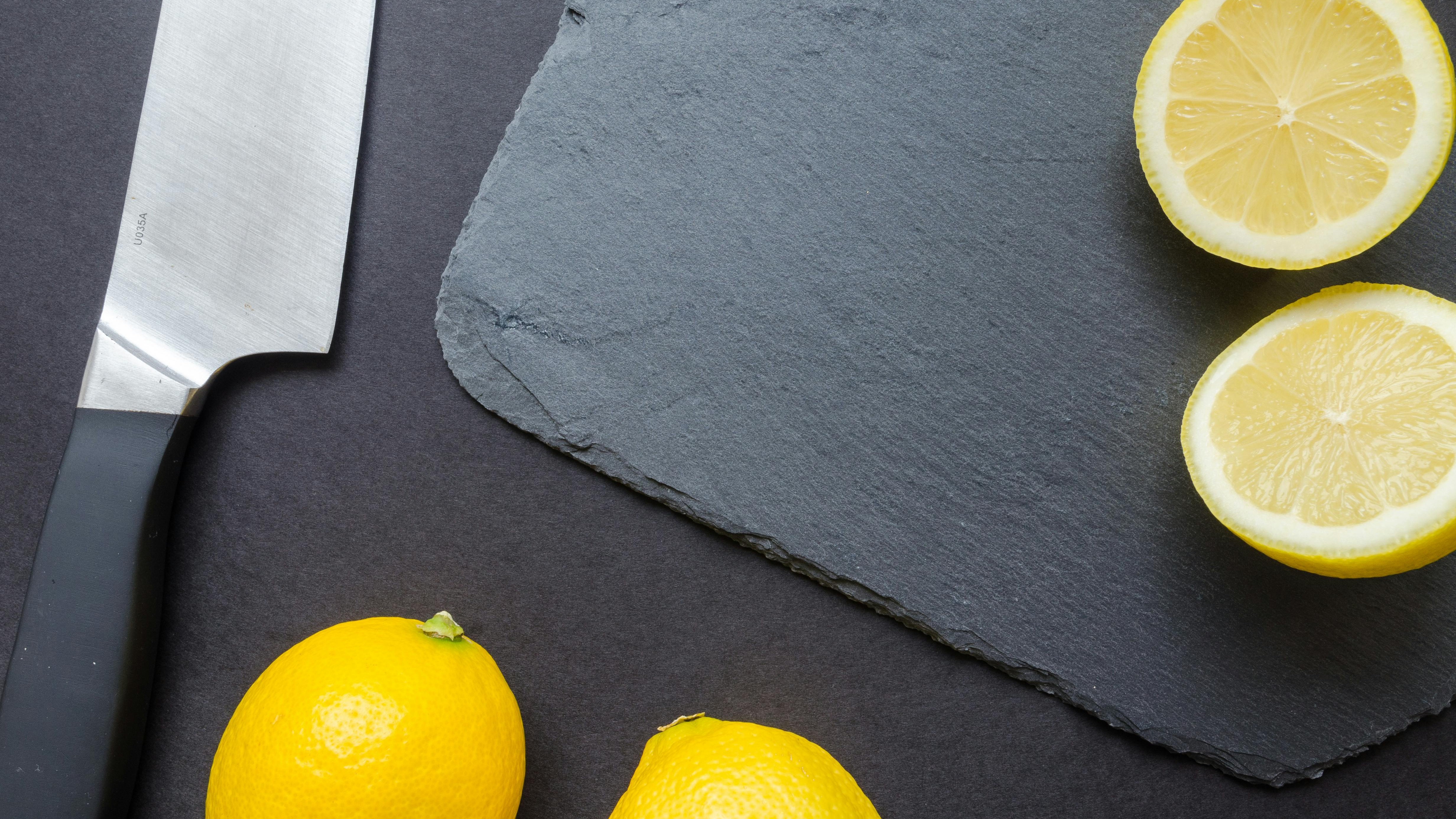 Person holding a clean, wood cutting board in a kitchen.
