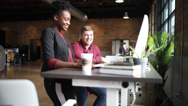 Three women collaborating in a bright office setting, ERG news 2025.