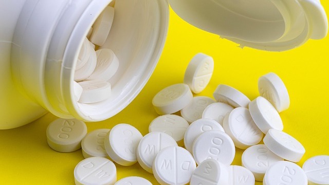 Prescription drug worry: Pills and money illustrating financial burden.