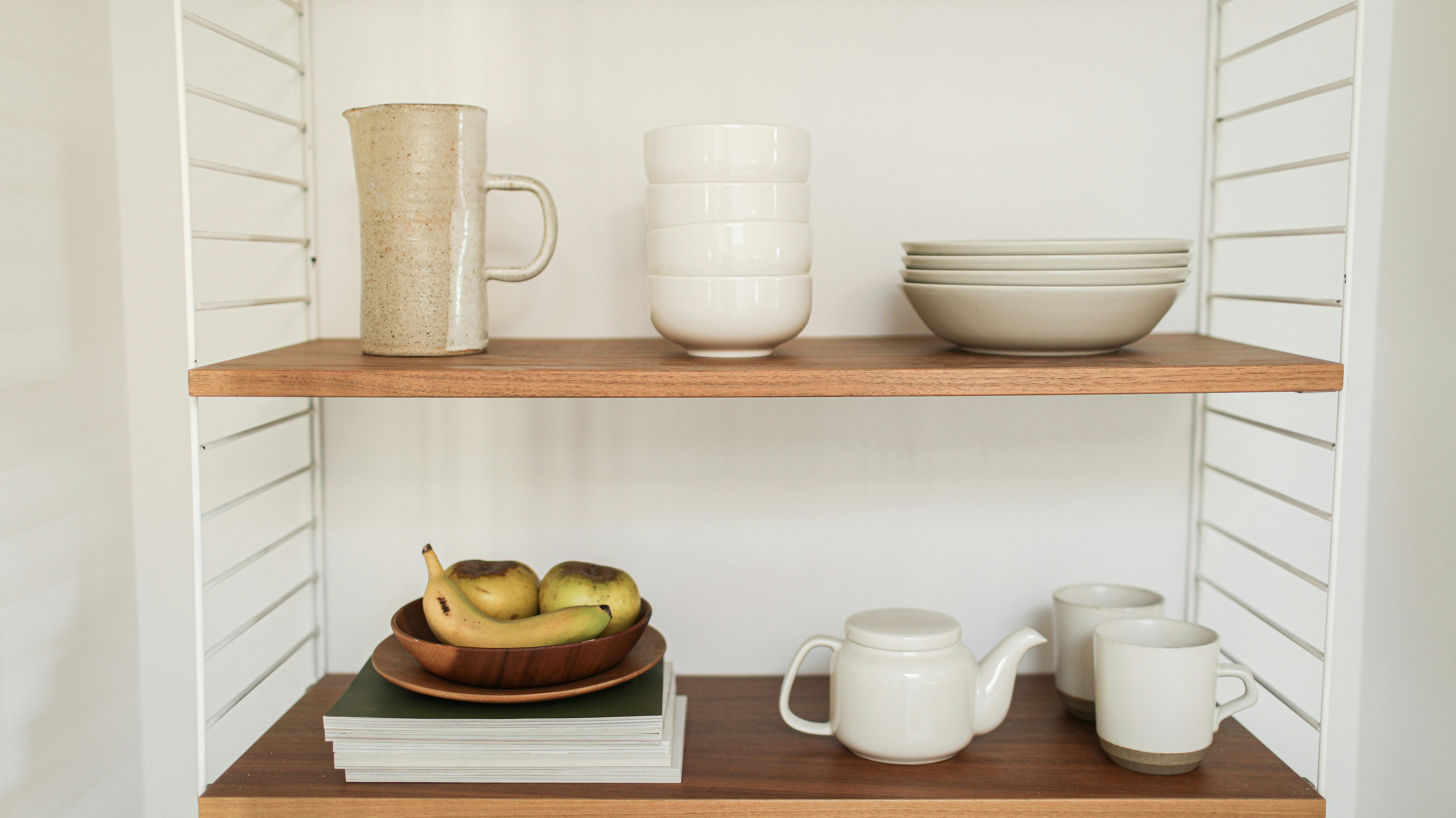 DIY mug display shelf with colorful mugs on a wooden wall mount.