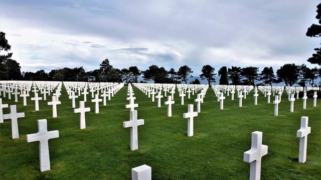 Tokens of Remembrance in Military Families, man honoring in rain-soaked cemetery.