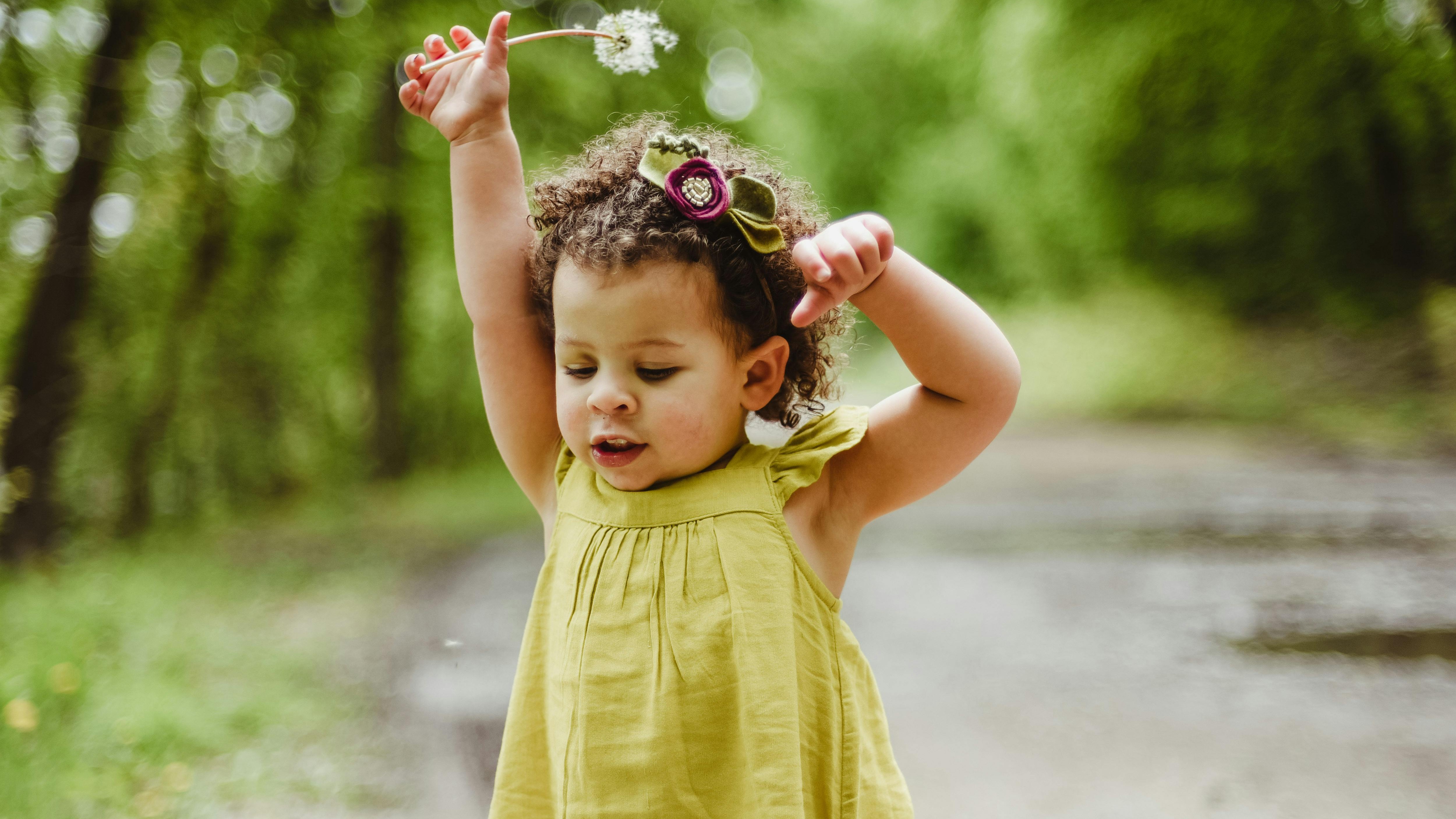 Toddler enjoying beach waves with adult, showcasing toddler behavior tips.