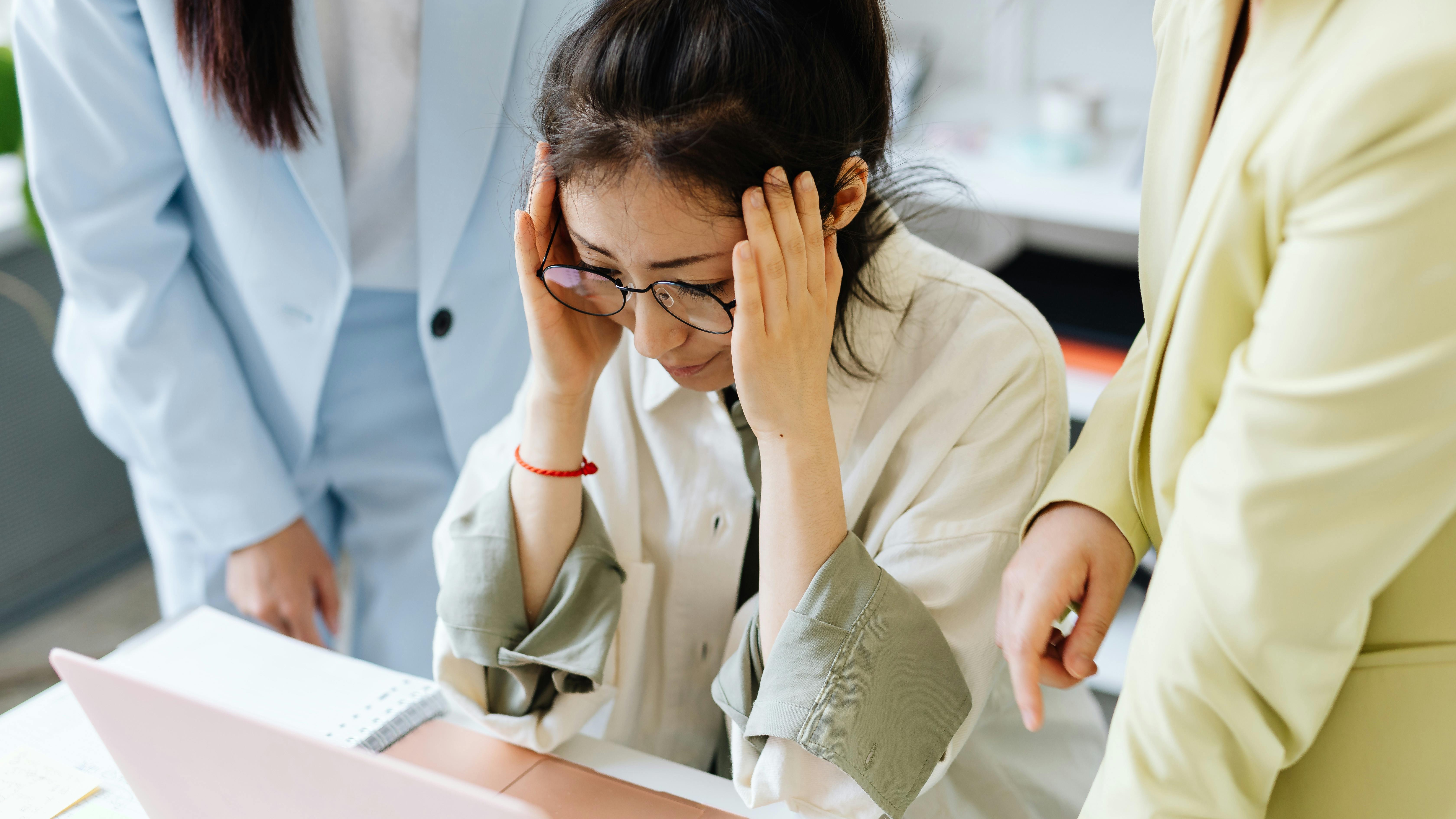 Young man experiencing workplace discrimination in an office setting.
