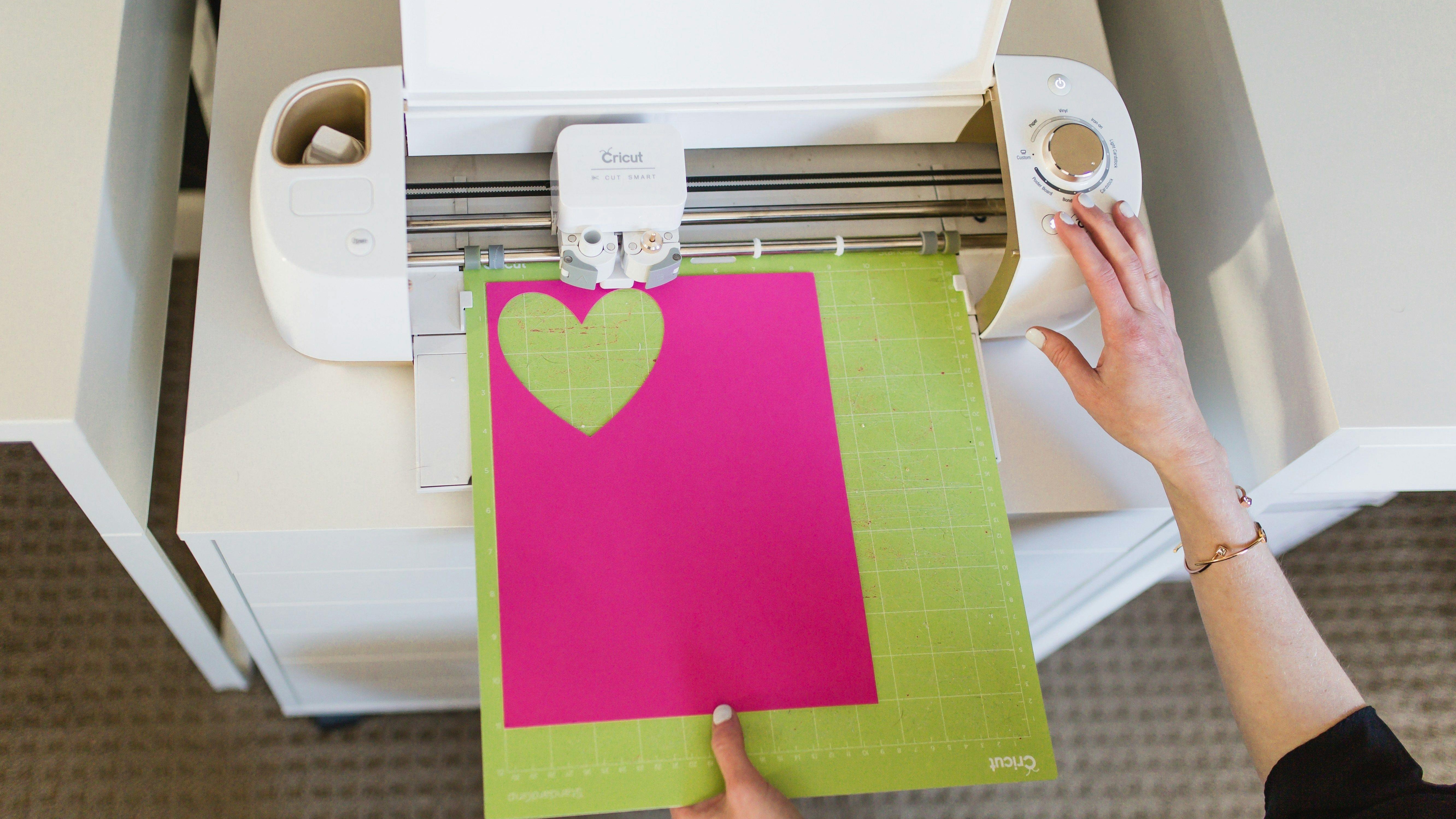 Cricut cutting machine setup showing mat and material.
