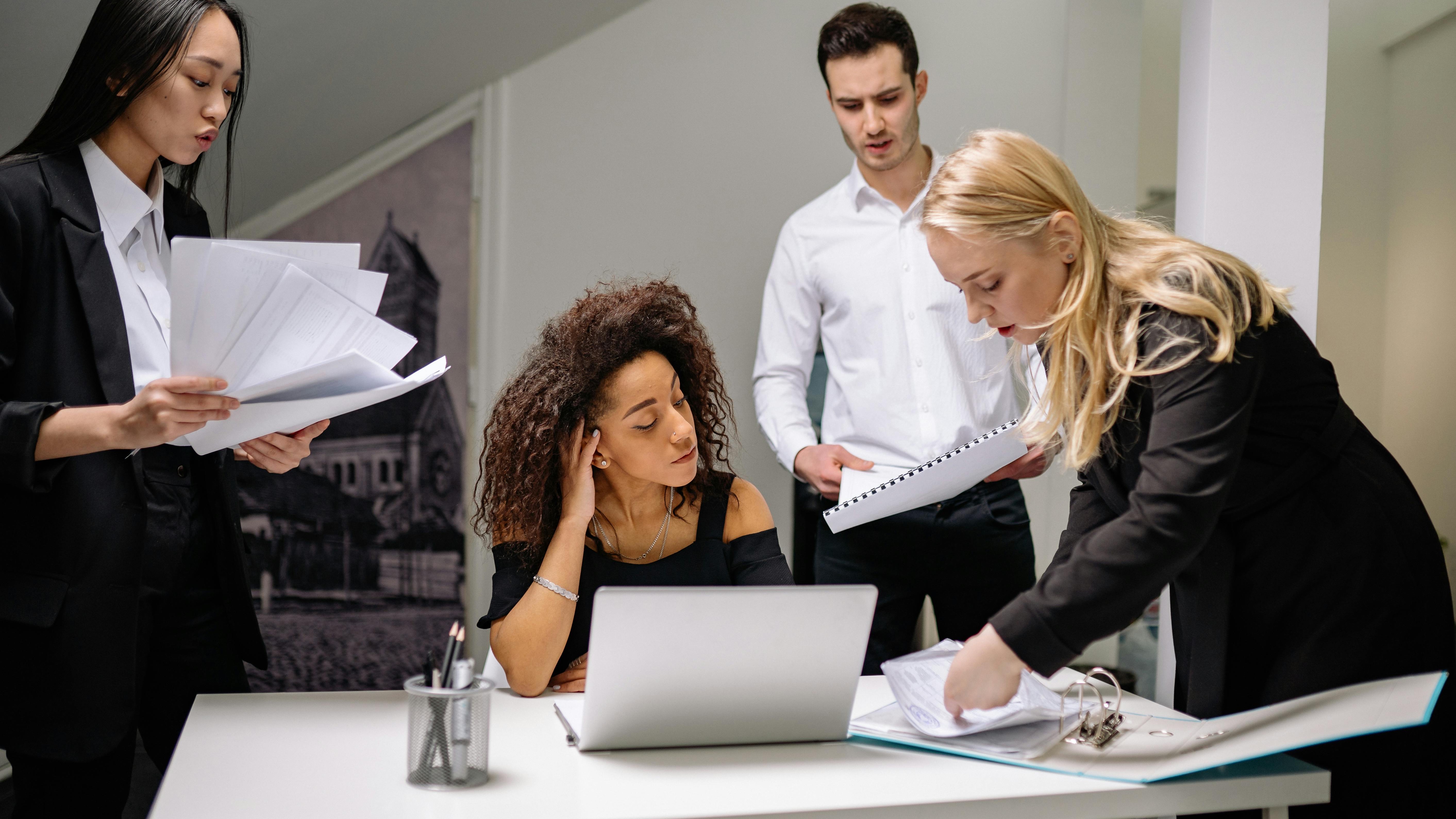 Mature man evaluates data charts on laptop, focusing on employee engagement strategies.