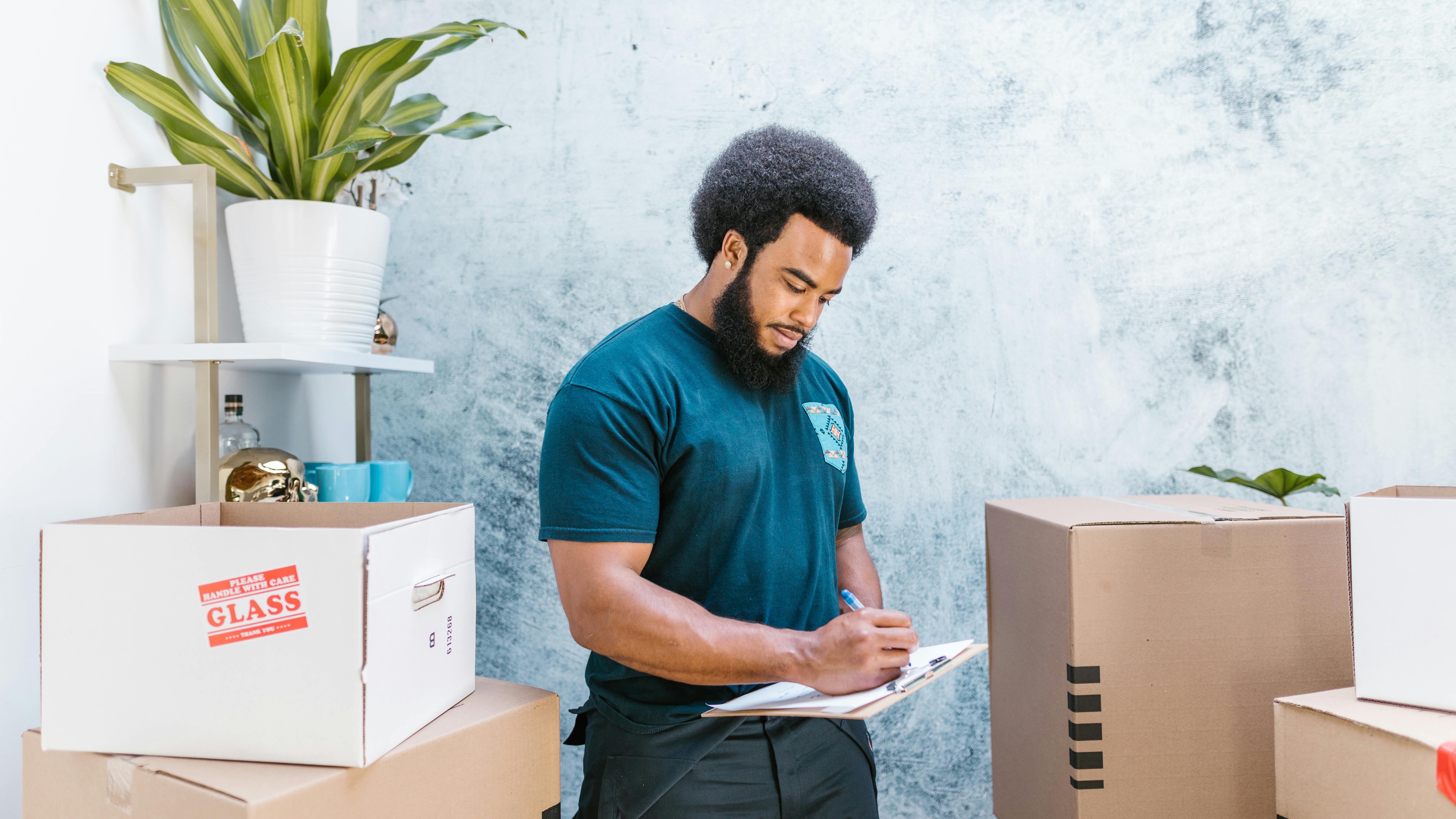 People loading moving truck on city street, family budgeting for moving out.