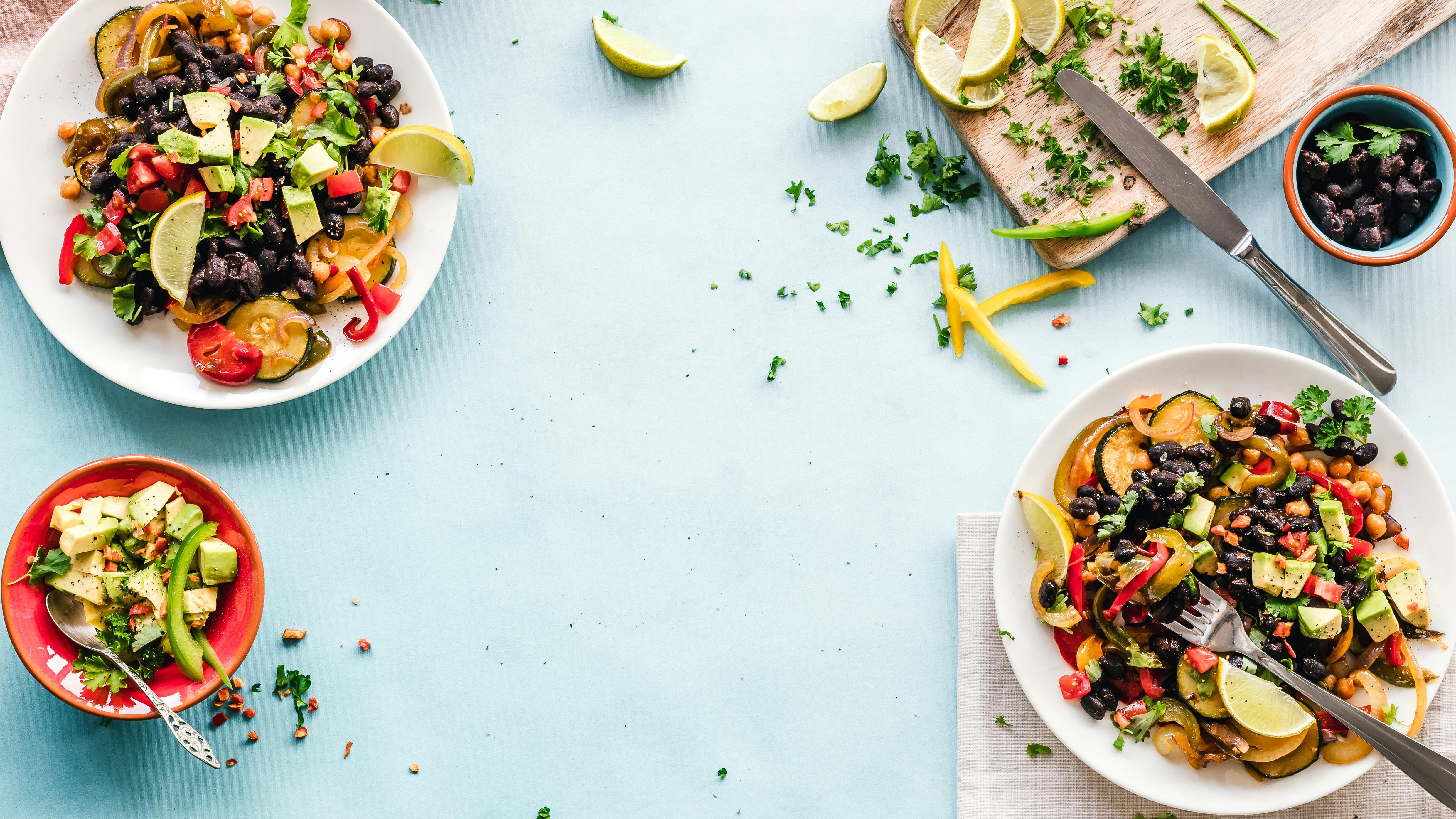 Diverse women holding cookbook 'Gather & Graze', blending cultures through cooking.