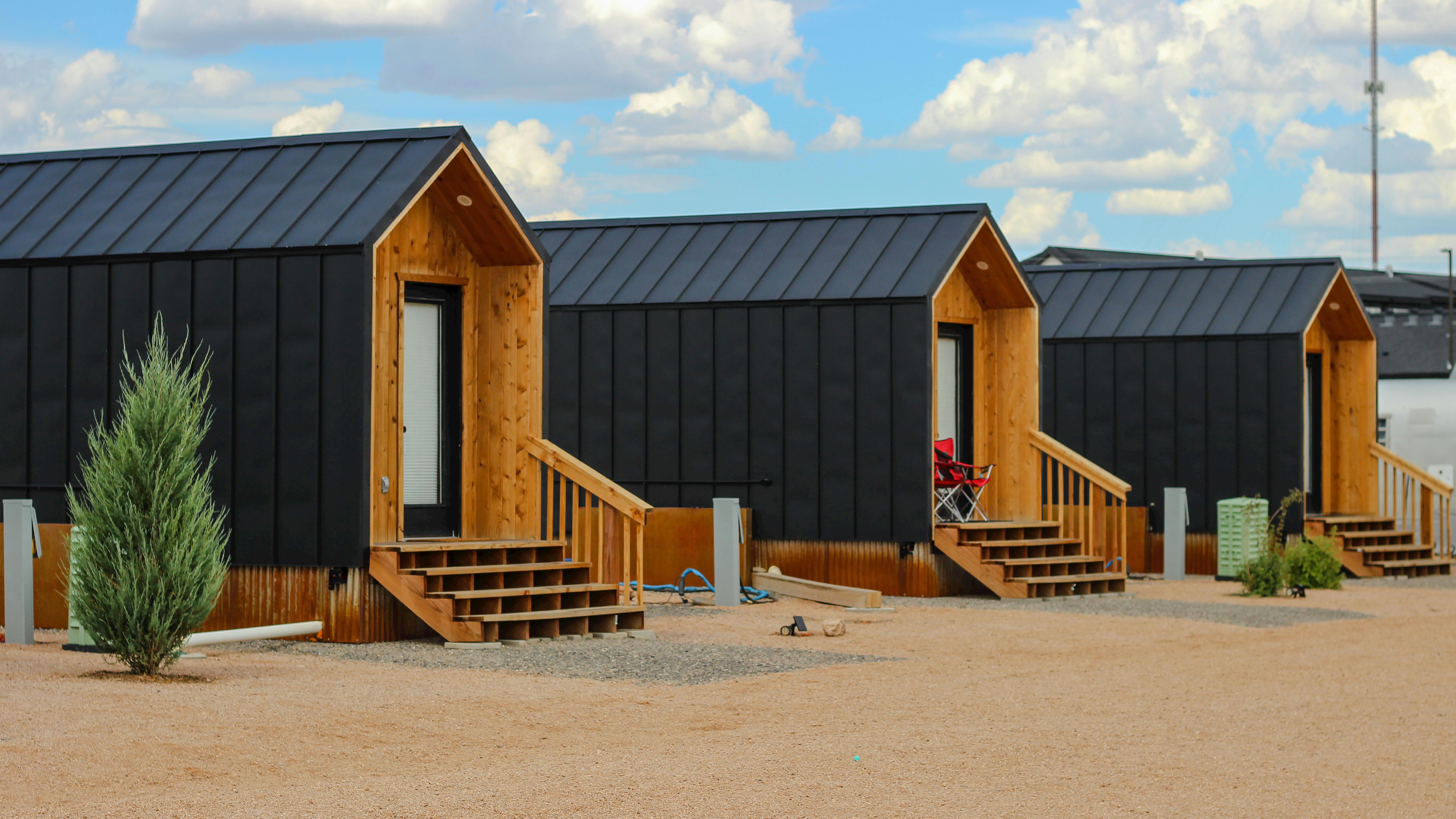 Modern tiny home in a lush Texas community, surrounded by trees.