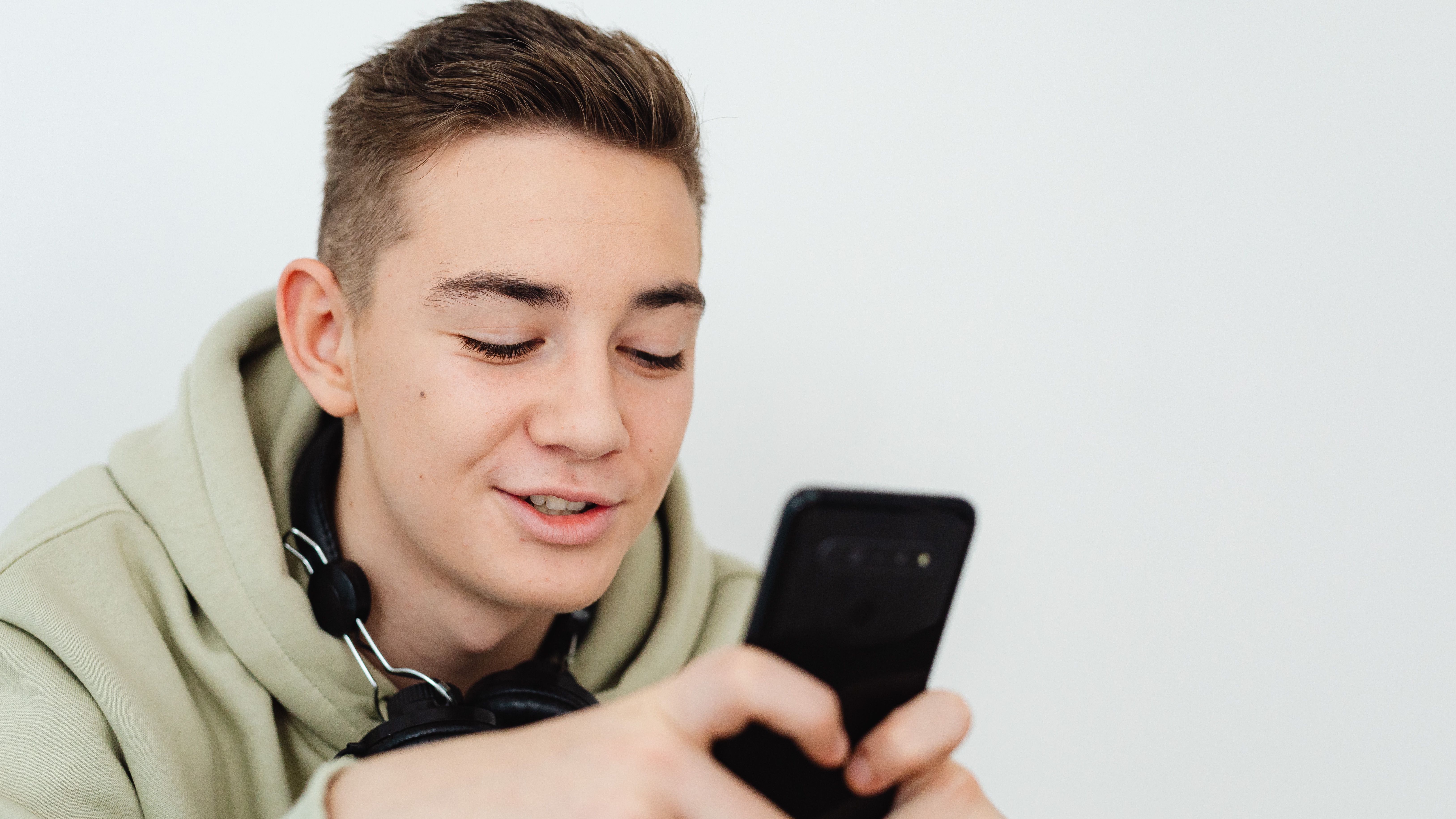 Young girl browsing Instagram at 13, focused expression outdoors.