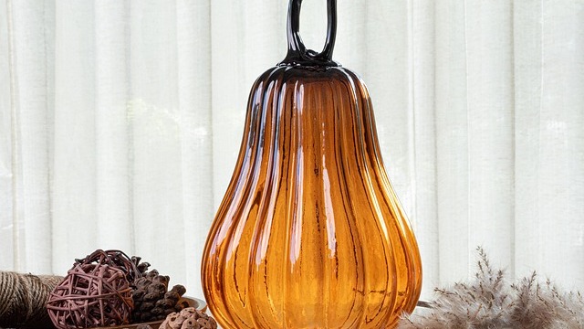 Tacky fall home decor with pumpkins and flowers on a porch.