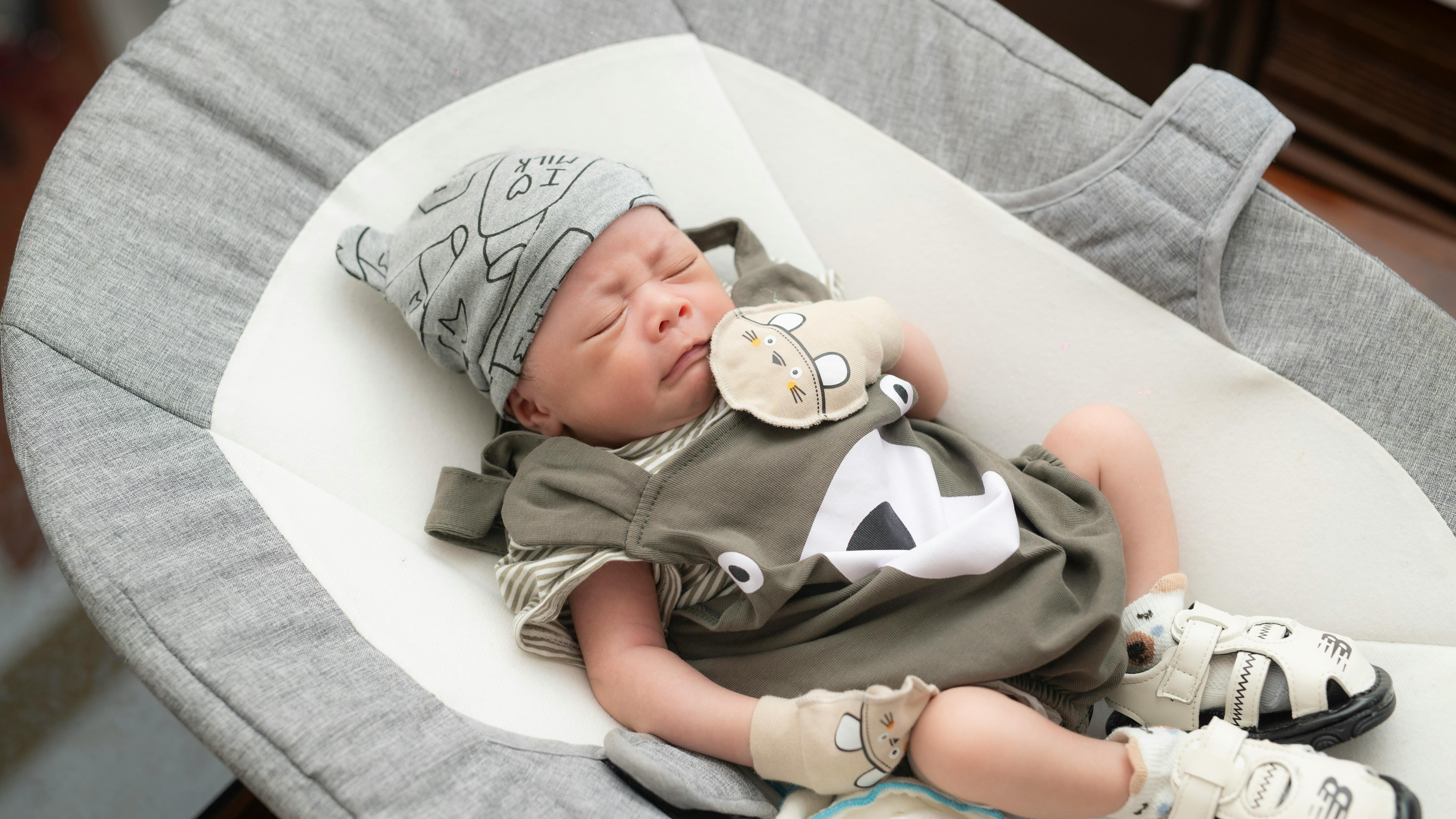 Mother placing baby into modern smart bassinet, best smart bassinets 2025.