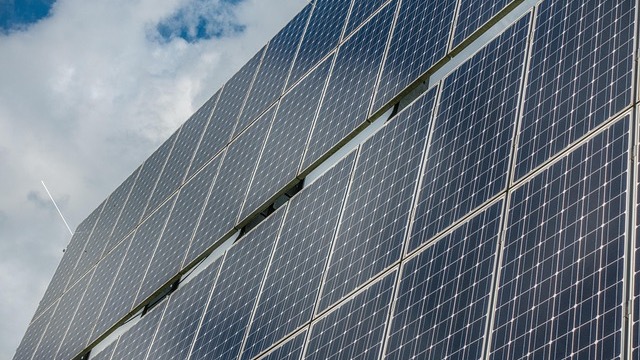 Residential rooftop with solar panels under a clear sky for solar energy efficiency.