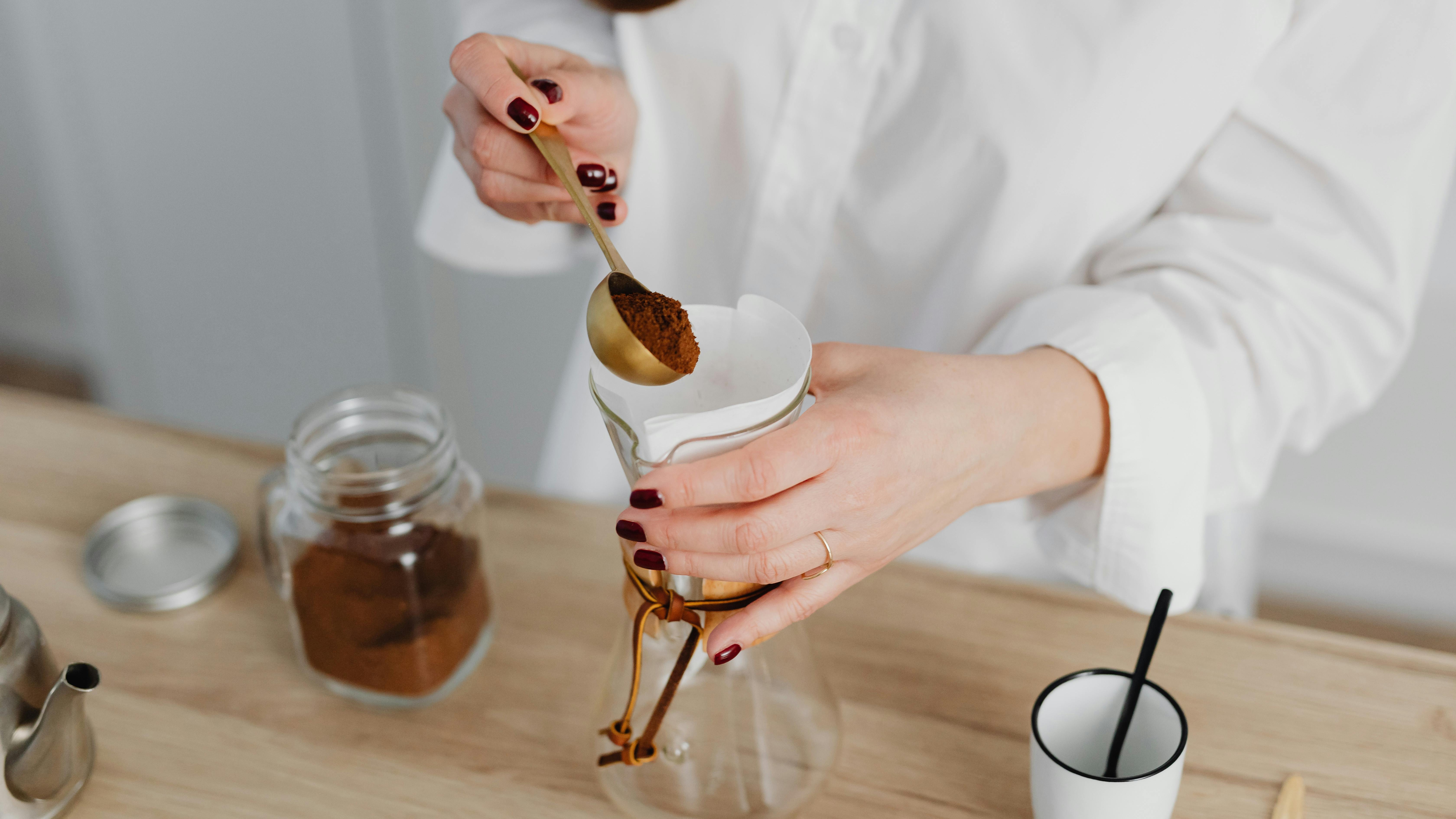 Breville Oracle Jet espresso machine on wooden table with plants.